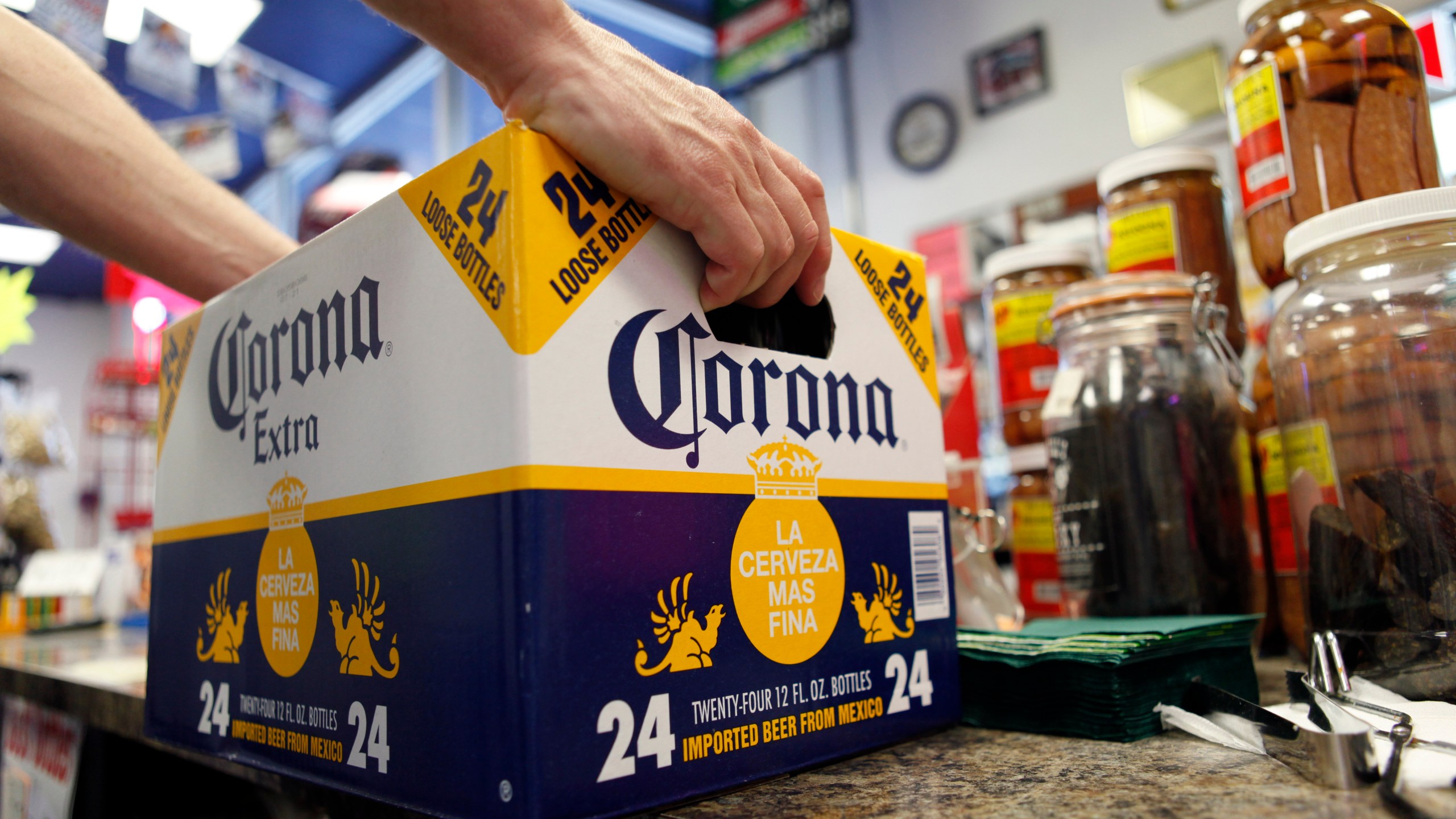 FILE - A customer places a case of Corona Extra on the checkout counter for purchase at Susquehanna Beer and Soda in Marysville, Pa, April 1, 2010. (AP Photo/Carolyn Kaster, File)
