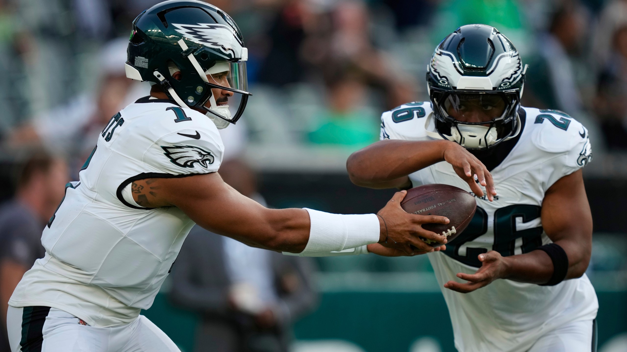 Philadelphia Eagles quarterback Jalen Hurts (1) hands off to Eagles running back Saquon Barkley (26) during warm ups before an NFL preseason football game against the Cincinnati Bengals on Thursday, Aug. 7, 2025, in Philadelphia. (AP Photo/Matt Slocum)