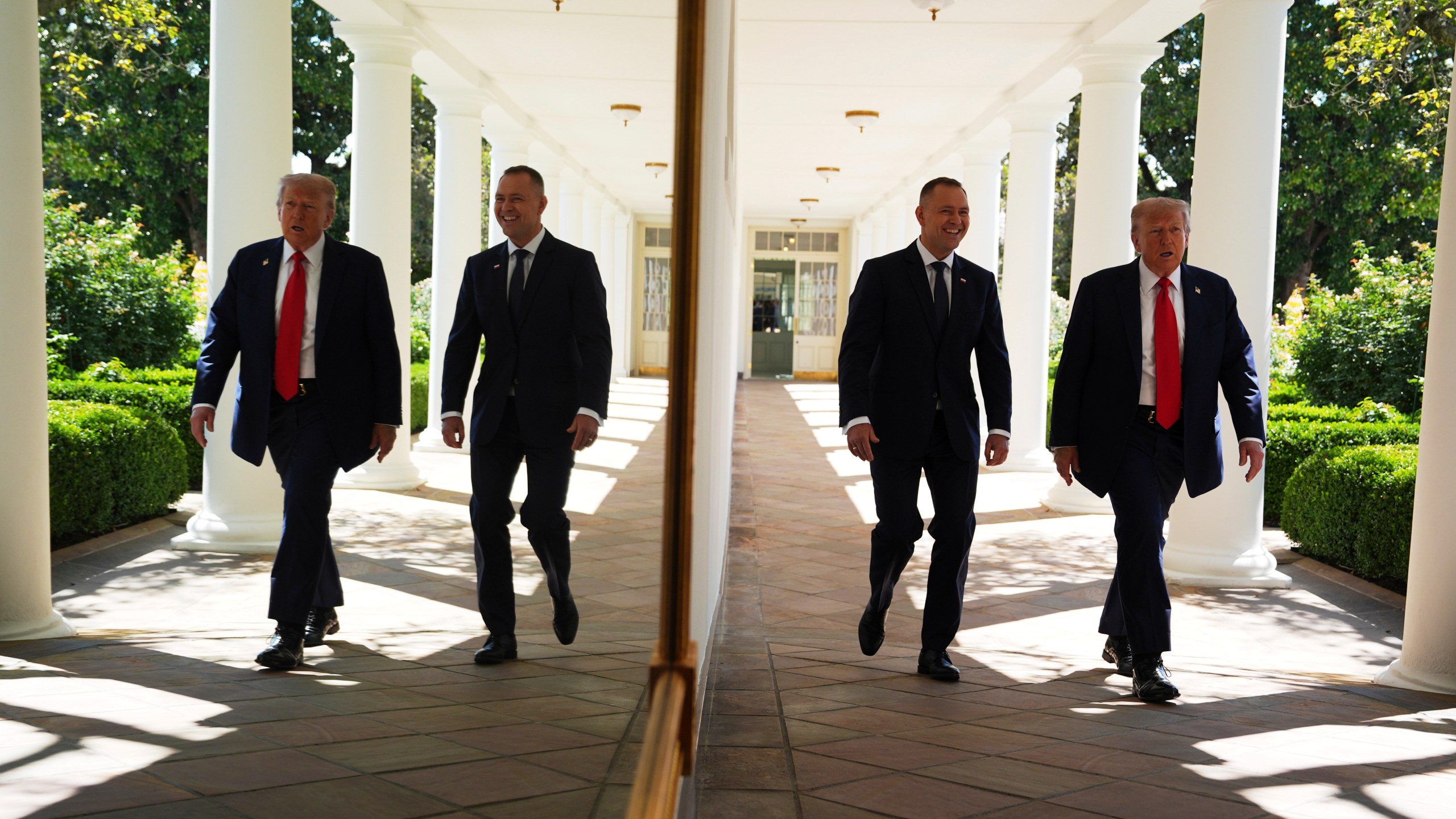 President Donald Trump and Polish President Karol Nawrocki, right, are seen reflected in the wall along the colonnade, as they walk toward an Oval Office meeting, at the White House, Wednesday, Sept. 3, 2025, in Washington. (AP Photo/Evan Vucci)