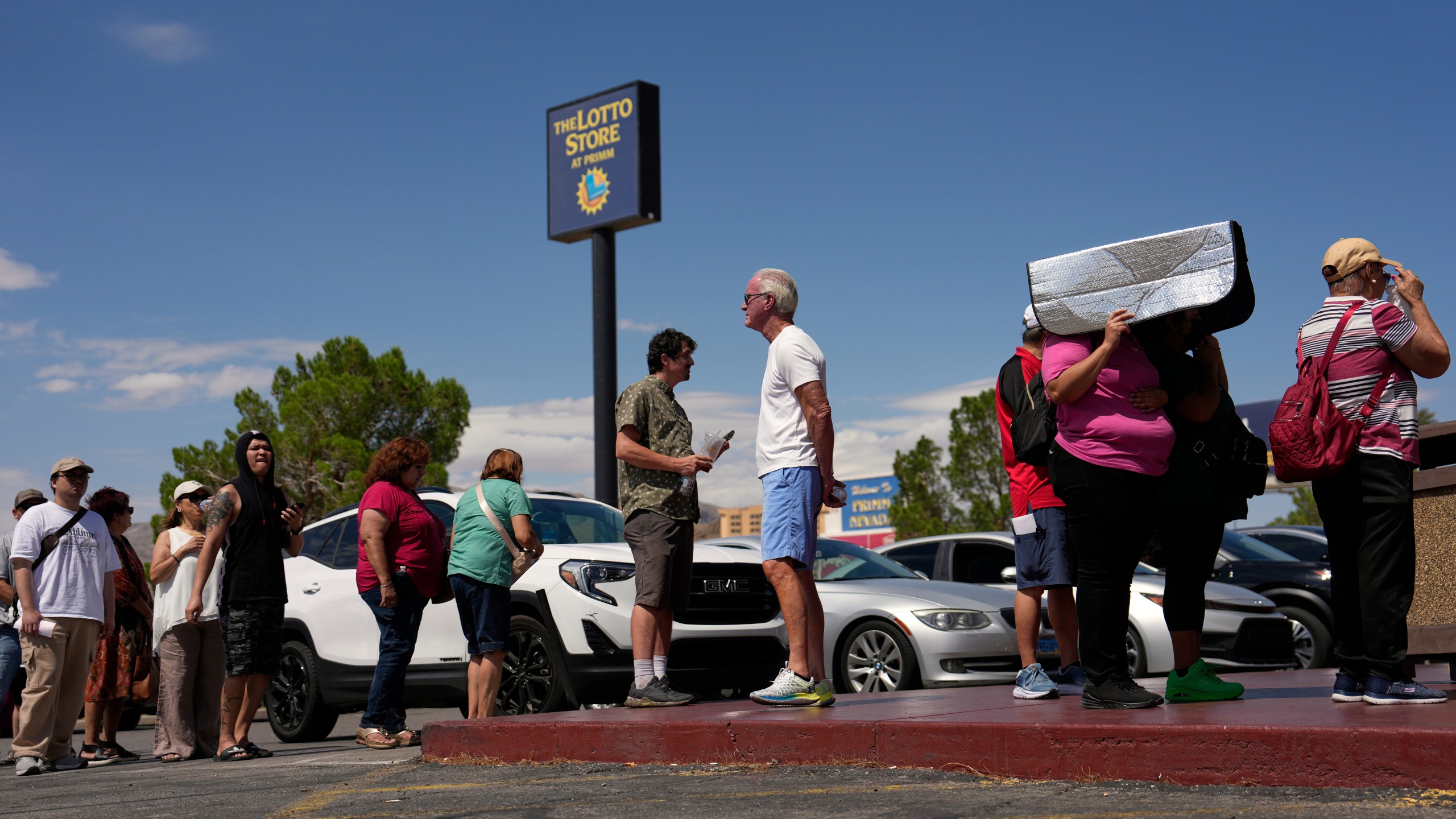 People wait in line to buy lottery tickets