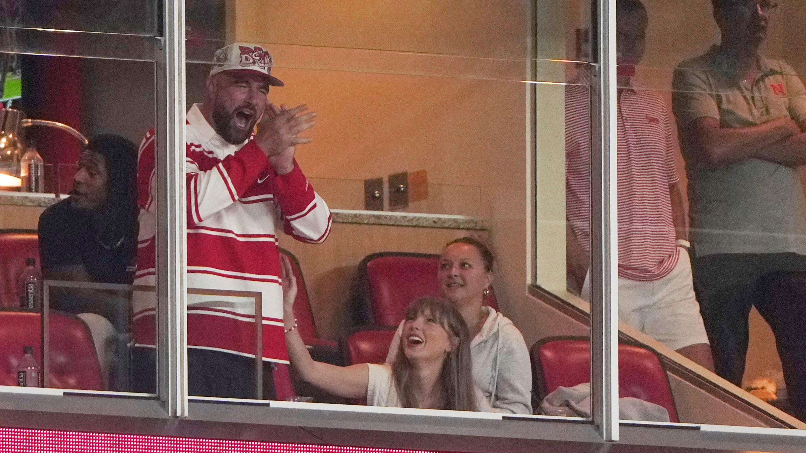 Taylor Swift sits with fiance Travis Kelce as they watch during the second half of an NCAA college football game between Cincinnati and Nebraska Thursday, Aug. 28, 2025, at Arrowhead Stadium in Kansas City, Mo. (AP Photo/Charlie Riedel)