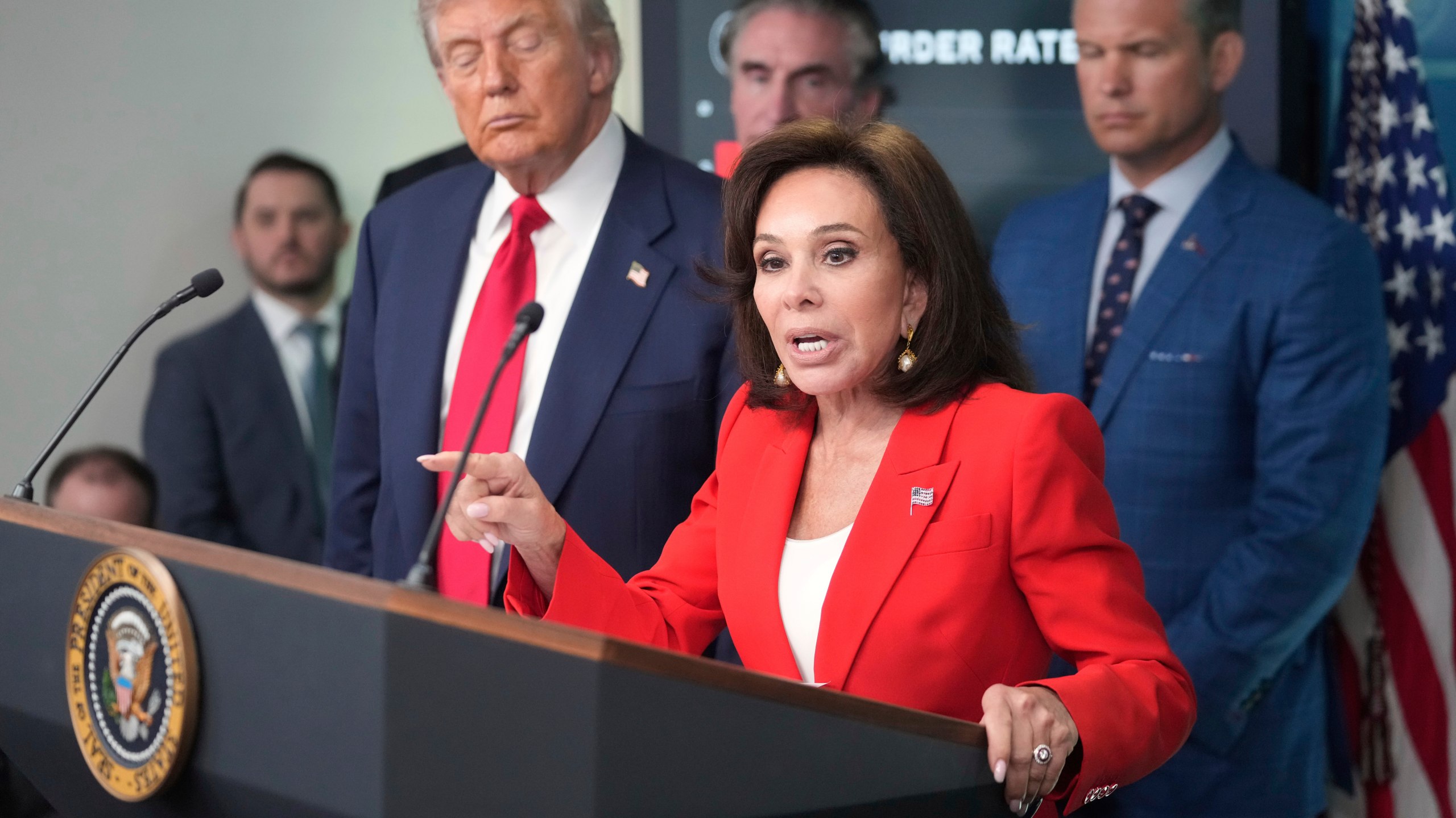U.S. Attorney Jeanine Pirro speaks with reporters as President Donald Trump, from left, Interior Secretary Doug Burgum and Defense Secretary Pete Hegseth listen in the James Brady Press Briefing Room at the White House, Monday, Aug. 11, 2025, in Washington. (AP Photo/Mark Schiefelbein)
