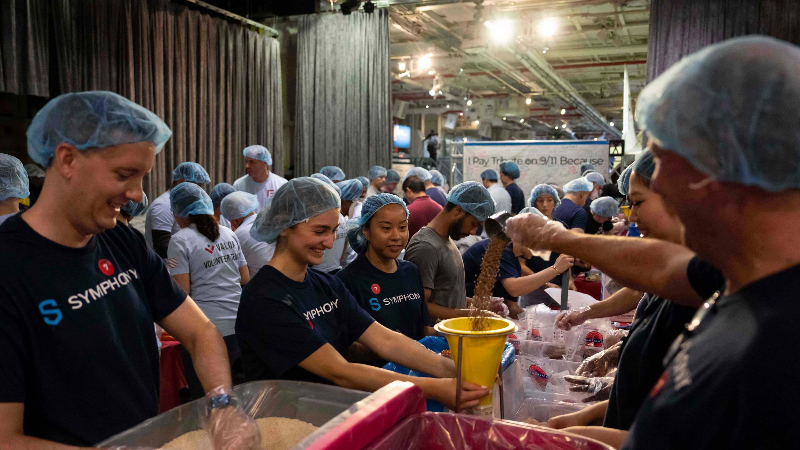Volunteers work during the "NYC Meal Pack For 9/11 Day" at the Intrepid Sea, Air & Space Museum, Wednesday, Sep. 10, 2025, in New York. (AP Photo/Yuki Iwamura)