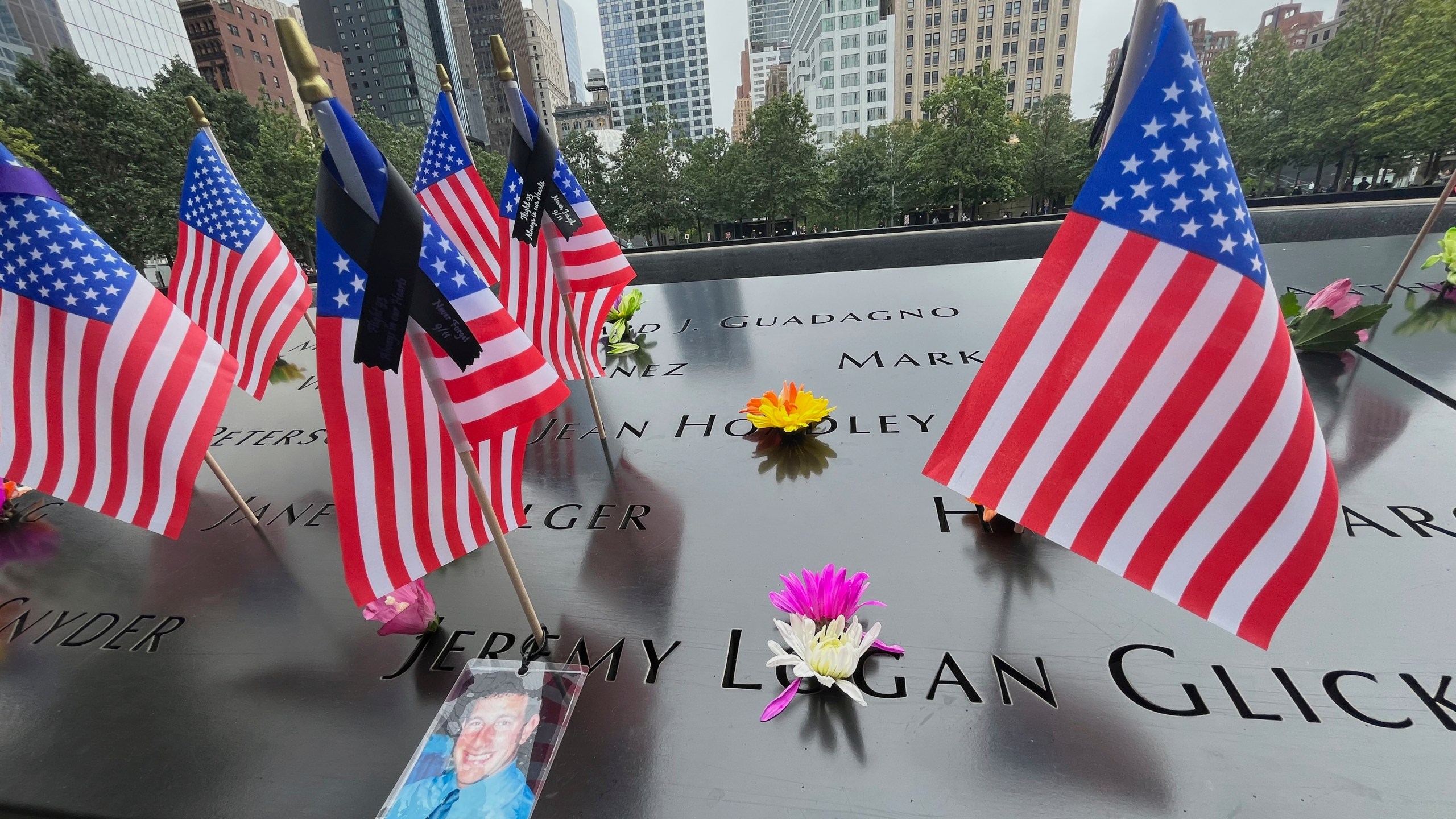 Flags and flowers are placed at the National September 11 Memorial