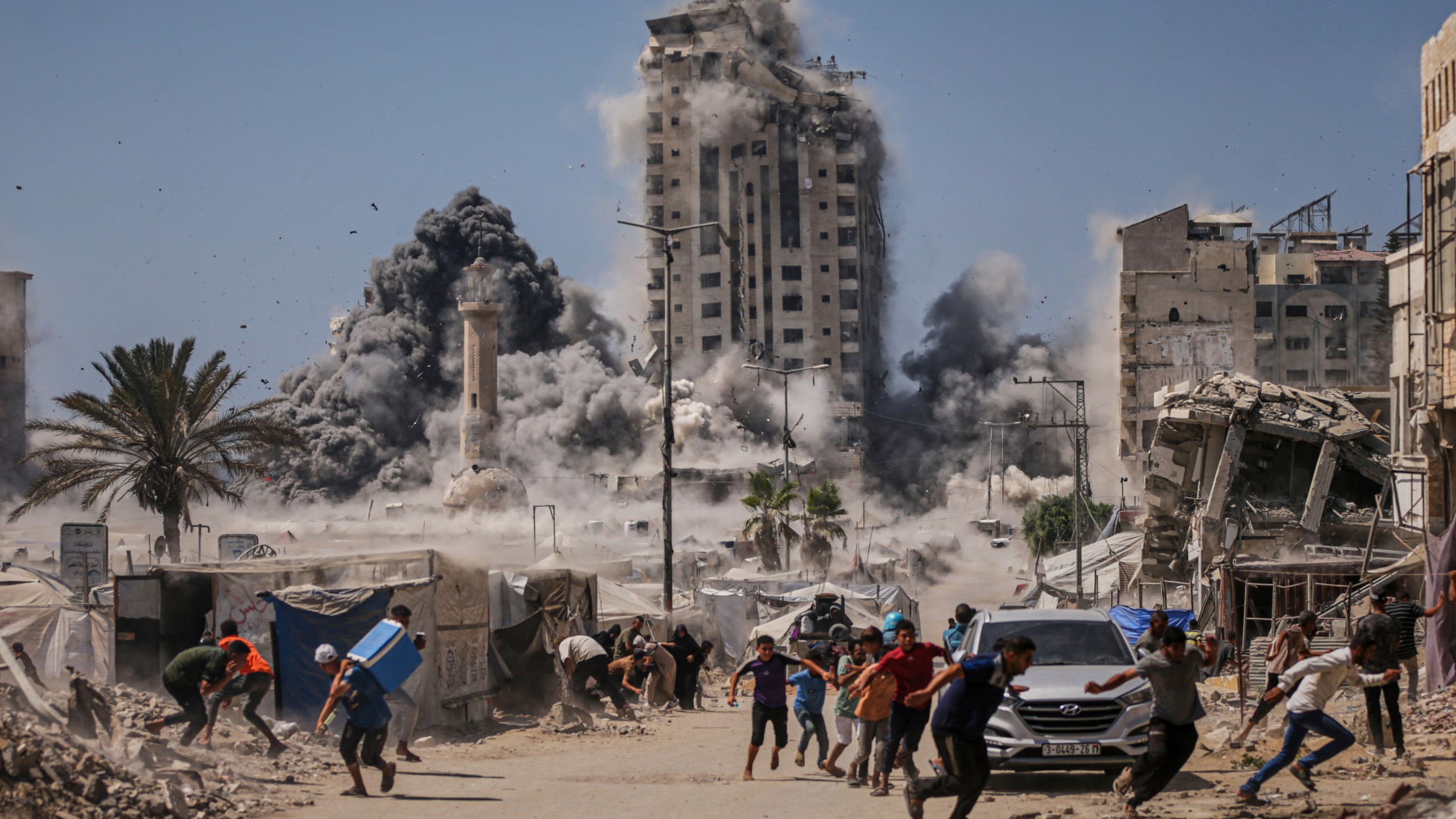 FILE - Palestinians run for cover during an Israeli airstrike on a high-rise building in Gaza City, Friday, Sept. 5, 2025, after the Israeli army issued a warning. (AP Photo/Yousef Al Zanoun, File)
