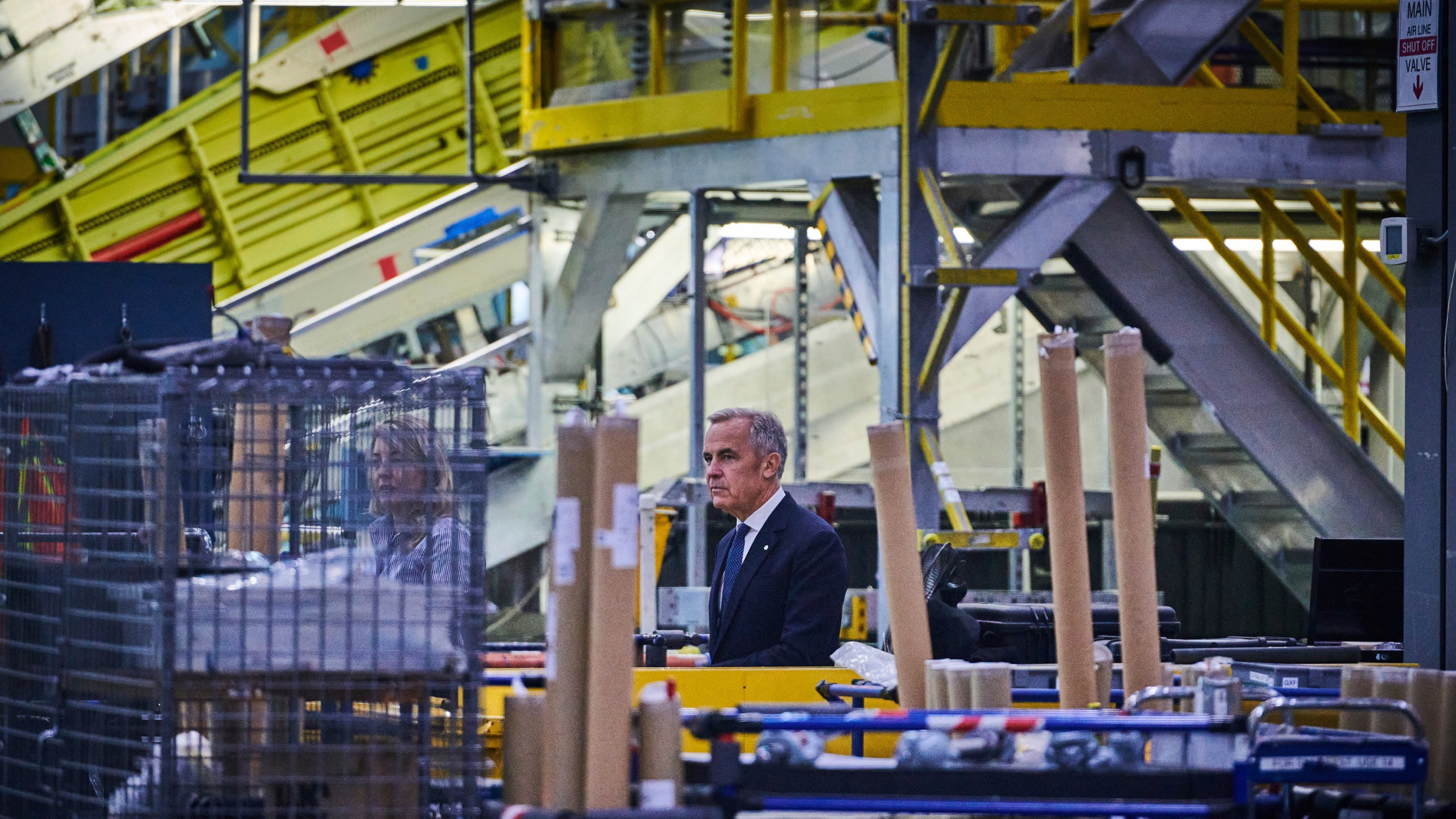 Prime Minister Mark Carney walks through a manufacturing facility ahead of a press conference in Mississauga, Ont., on Friday, Sept. 5, 2025. (Sammy Kogan /The Canadian Press via AP)