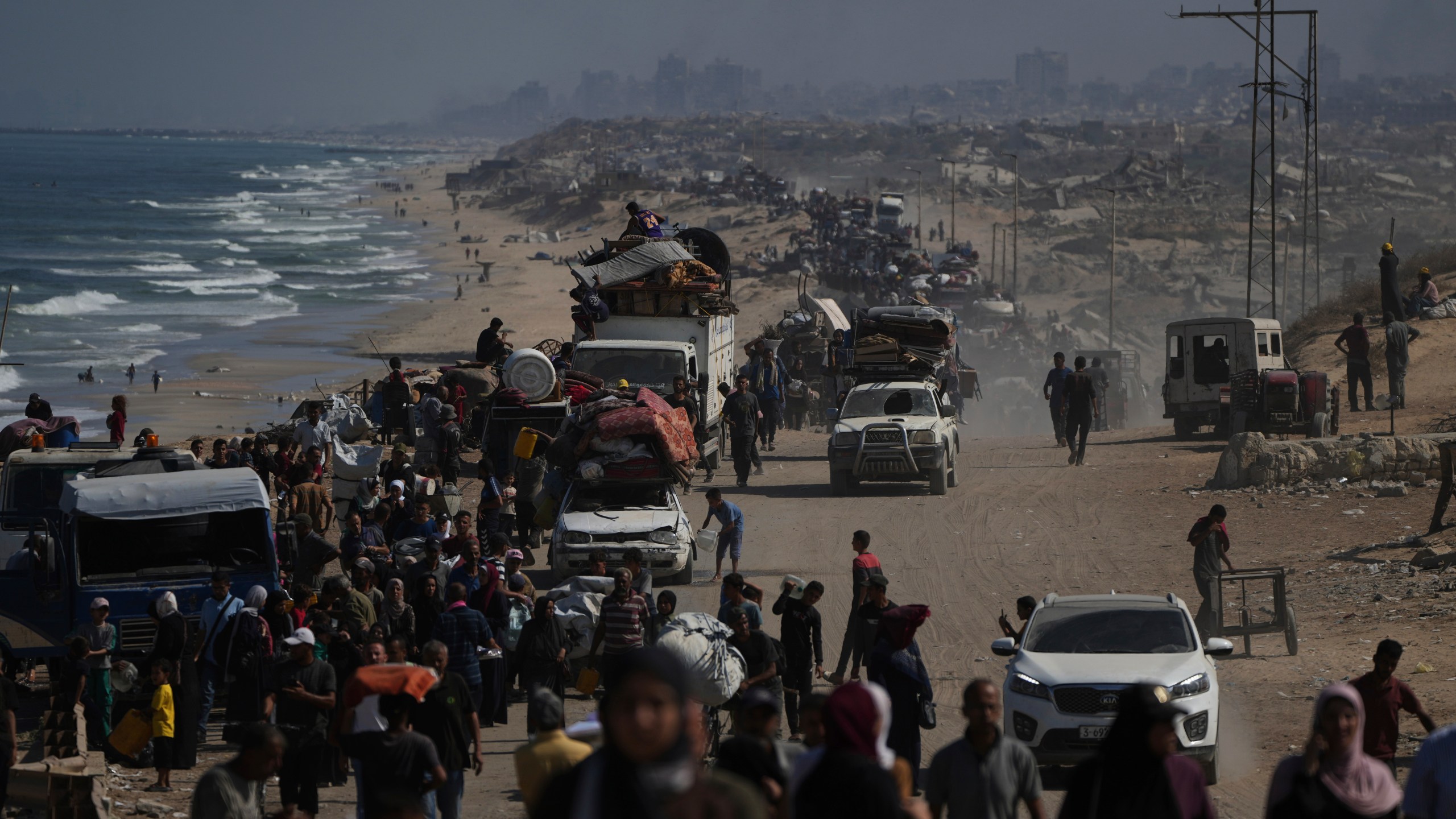 Displaced Palestinians flee Gaza City by foot and vehicles, carrying their belongings along the coastal road toward southern Gaza, Wednesday, Sept. 17, 2025. (AP Photo/Abdel Kareem Hana)