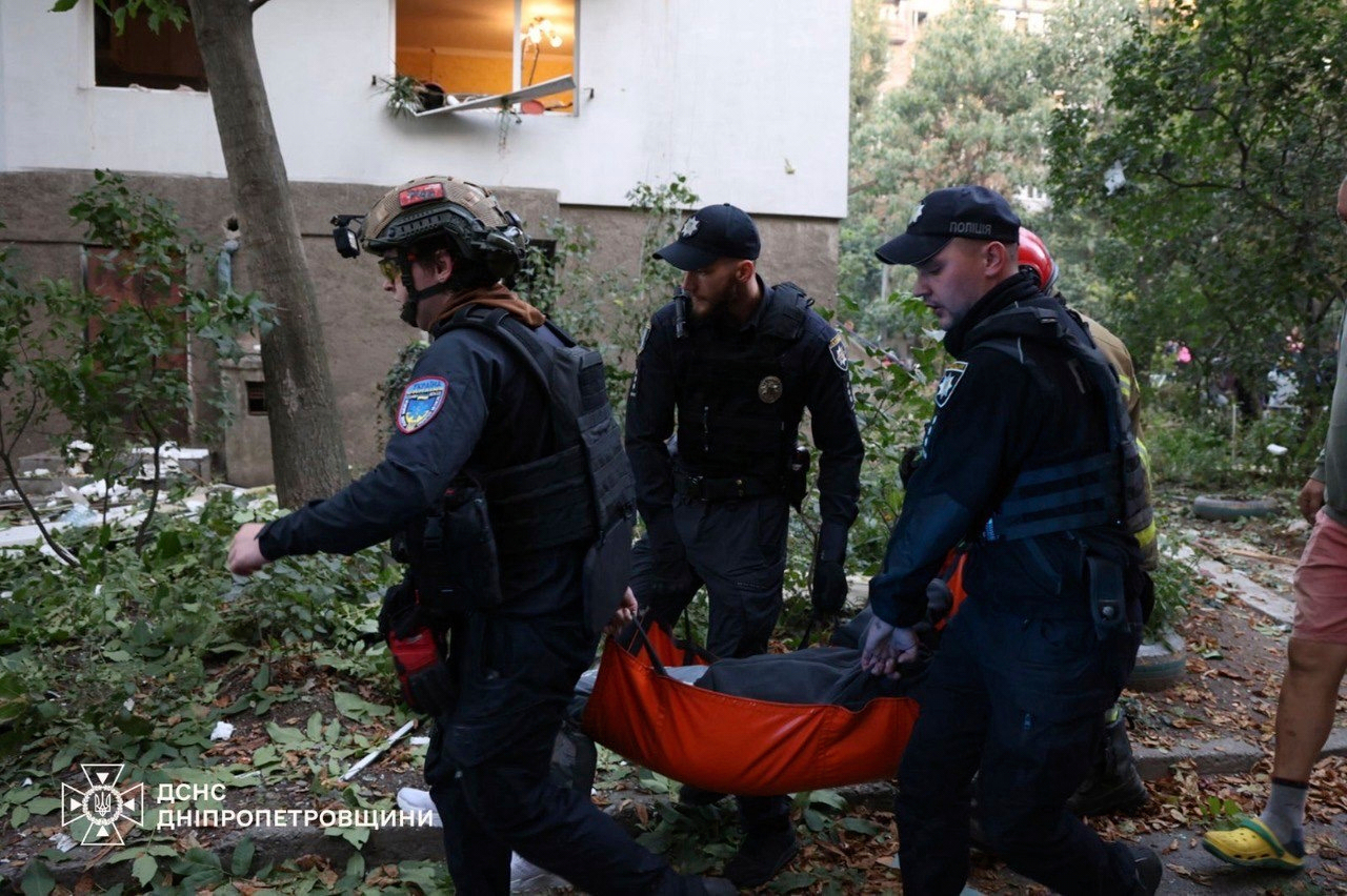 In this photo provided by the Ukrainian Emergency Services on Saturday, Sept. 20, 2025, policemen carry an injured person from a residential house damaged by a Russian strike on Dnipro, Ukraine. (Ukrainian Emergency Service via AP)