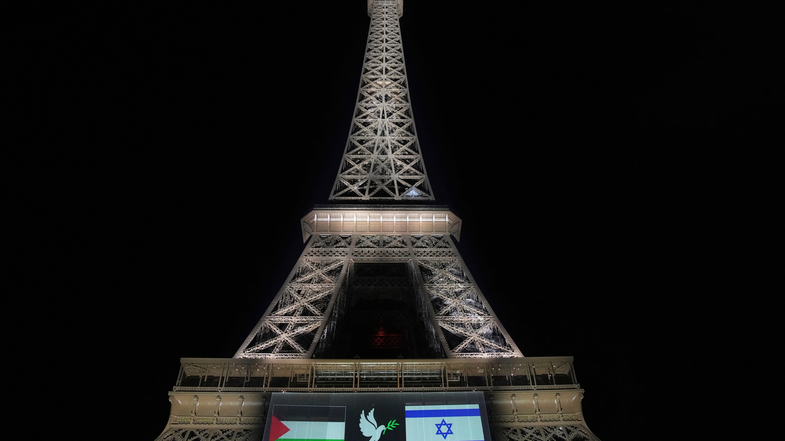 A large screen displays Palestinian and Israeli flags and a dove on the Eiffel Tower, Sunday, Sept. 21, 2025, in Paris, as France prepares to formally recognize a Palestinian state at the United Nations General Assembly. (AP Photo/Christophe Ena)