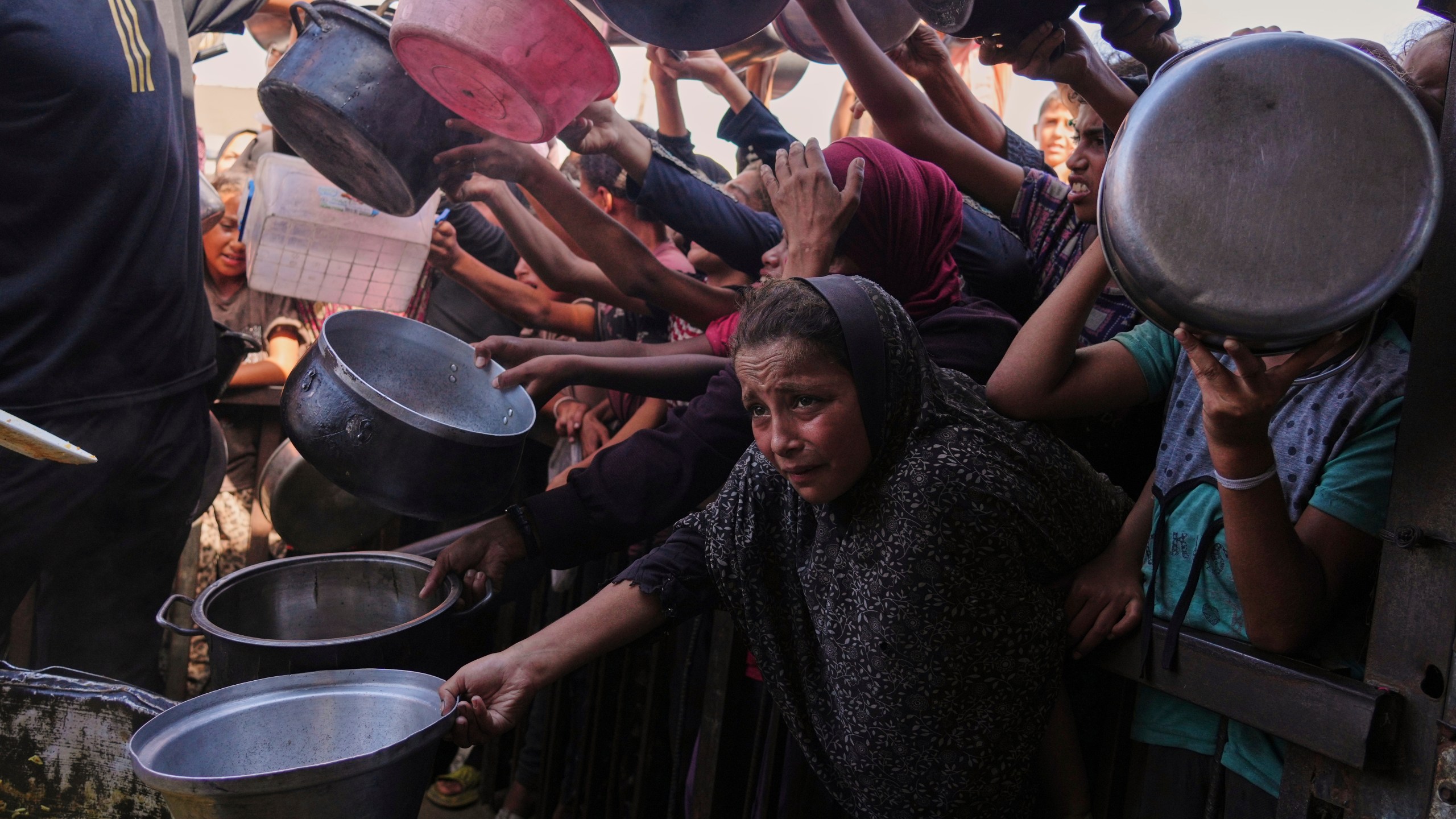 FILE - Palestinians struggle to get donated food at a community kitchen in Khan Younis, southern Gaza Strip, Friday, Sept. 19, 2025. (AP Photo/Jehad Alshrafi, File)