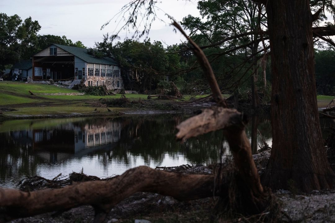 FILE - A building at Camp Mystic is reflected in water after a flash flood swept through the area, July 7, 2025, in Hunt, Texas. (AP Photo/Eli Hartman, File)
