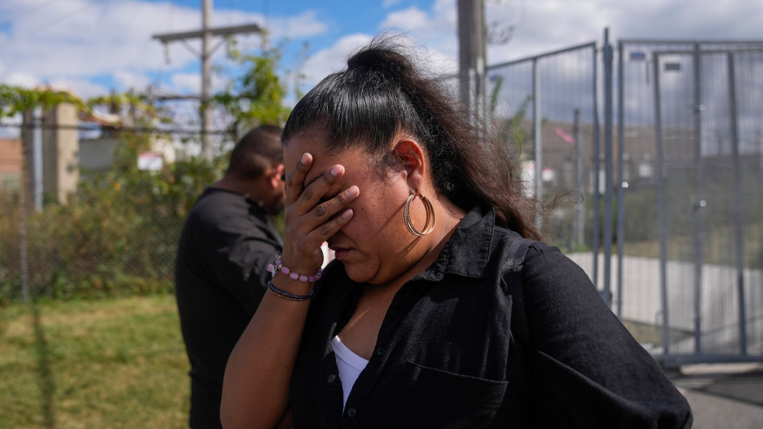 Jessica Aguilar and her son John are emotional after passing diabetes medication for her husband Carlos Aguilar, who she said was taken by unidentified agents in DeKalb on his way to work this morning, to a federal agent through a fence outside the U.S. Immigration and Customs Enforcement (ICE) building Wednesday, Sept. 24, 2025, in Broadview, Ill. (AP Photo/Erin Hooley)