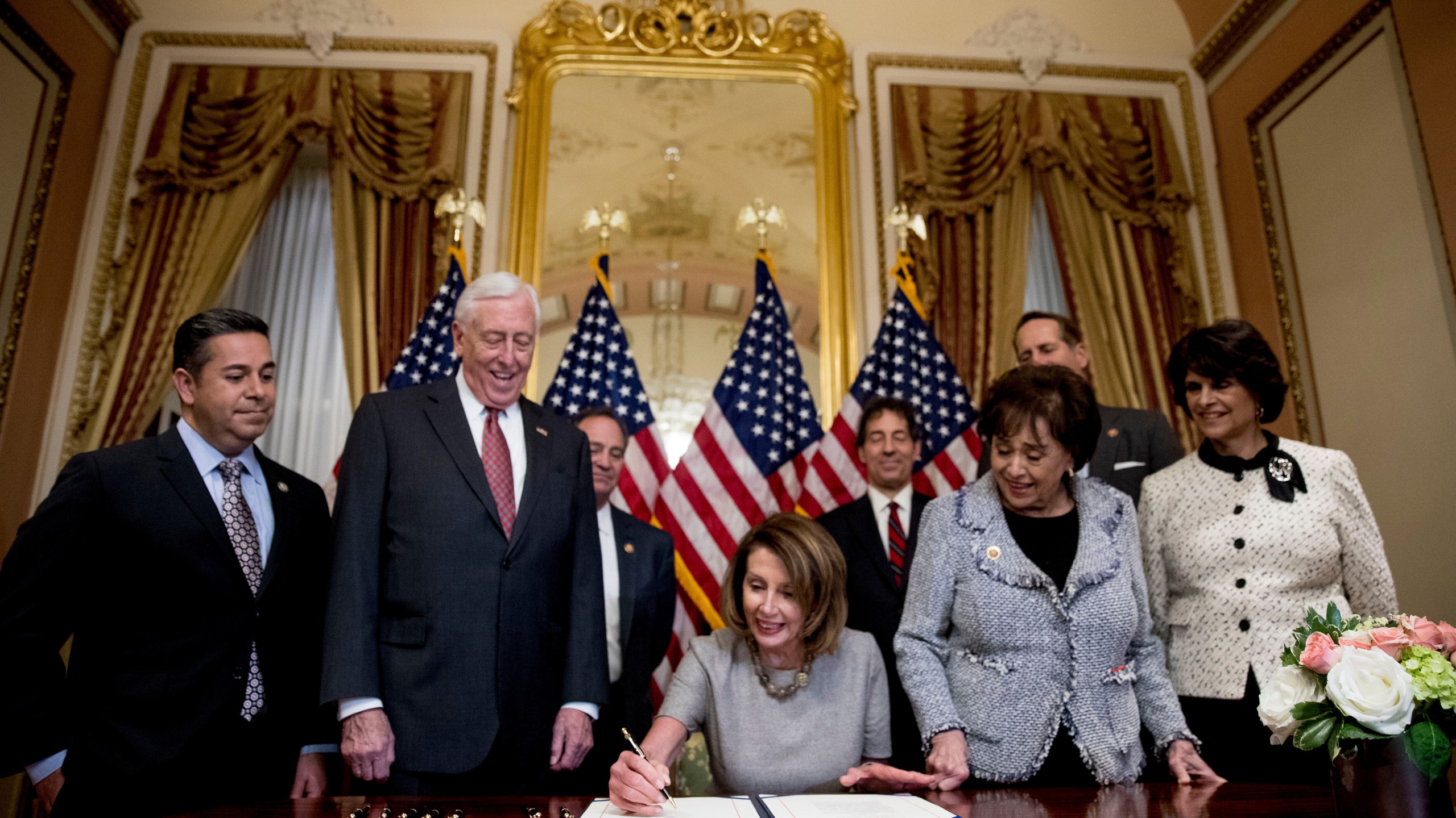 FILE - House Speaker Nancy Pelosi of Calif., center, accompanied by from left, Rep. Ben Ray Lujan, D-N.M., House Majority Leader Steny Hoyer of Md., Rep. Nita Lowey, D-N.Y, Rep. Lucille Roybal-Allard, D-Calif., and others, signs a deal to reopen the government on Capitol Hill in Washington, Jan. 25, 2019. (AP Photo/Andrew Harnik, File)