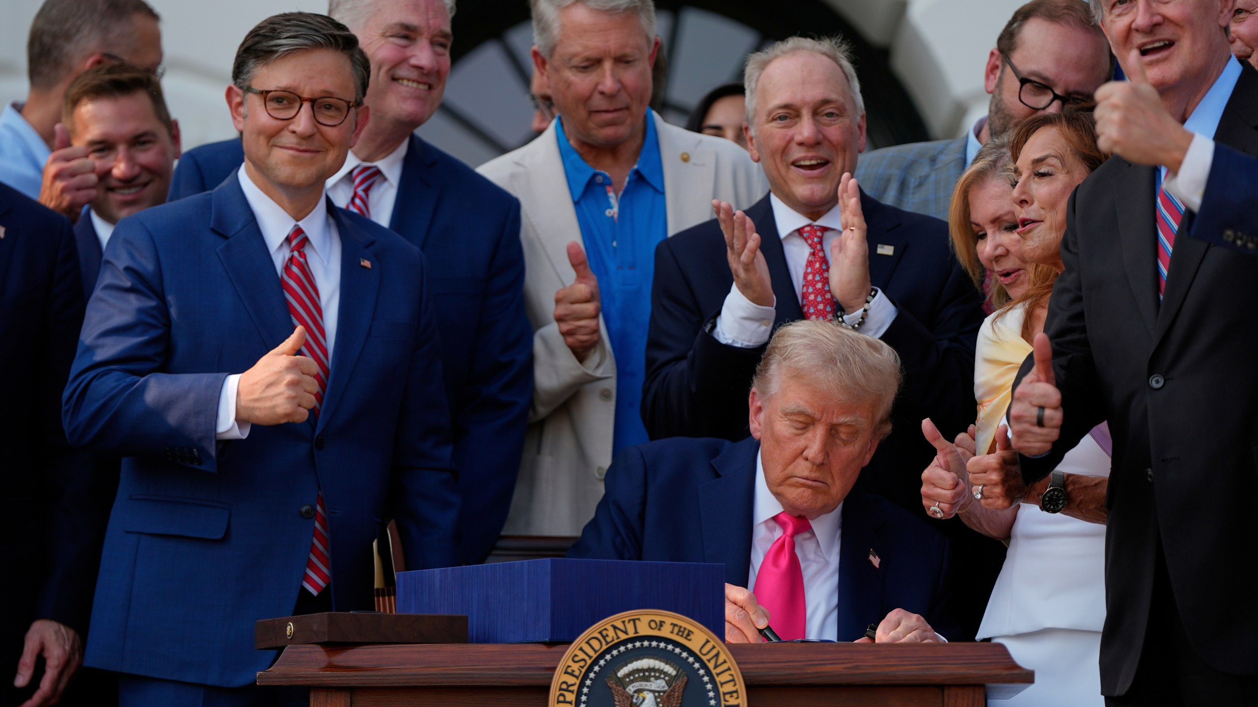 FILE - President Donald Trump signs his signature bill of tax breaks and spending cuts at the White House, July 4, 2025, in Washington, surrounded by members of Congress. (AP Photo/Julia Demaree Nikhinson, File)