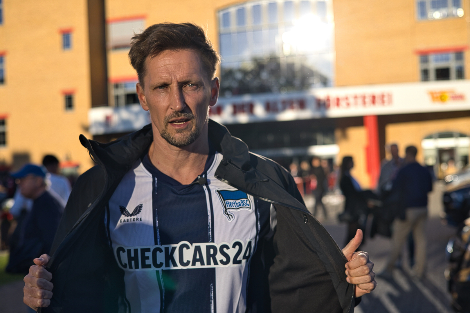 Thomas Melchior unveils a Hertha Berlin jersey before he tries to talk to Union Berlin fans about sports betting in Köpenick, Berlin, Sunday, Sept. 28, 2025. (AP Photo/Ciaran Fahey)
