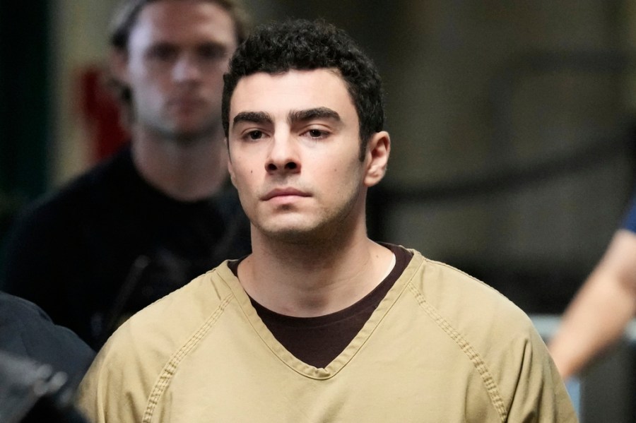 Luigi Mangione, wearing a beige jumpsuit and handcuffs, is escorted into court