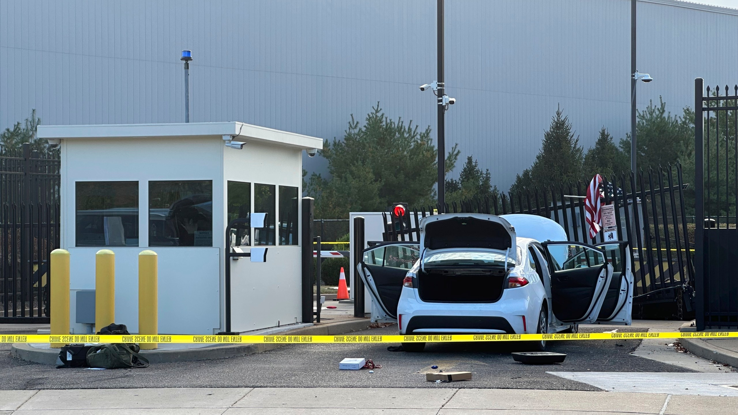 A white car pictured stuck in a gate