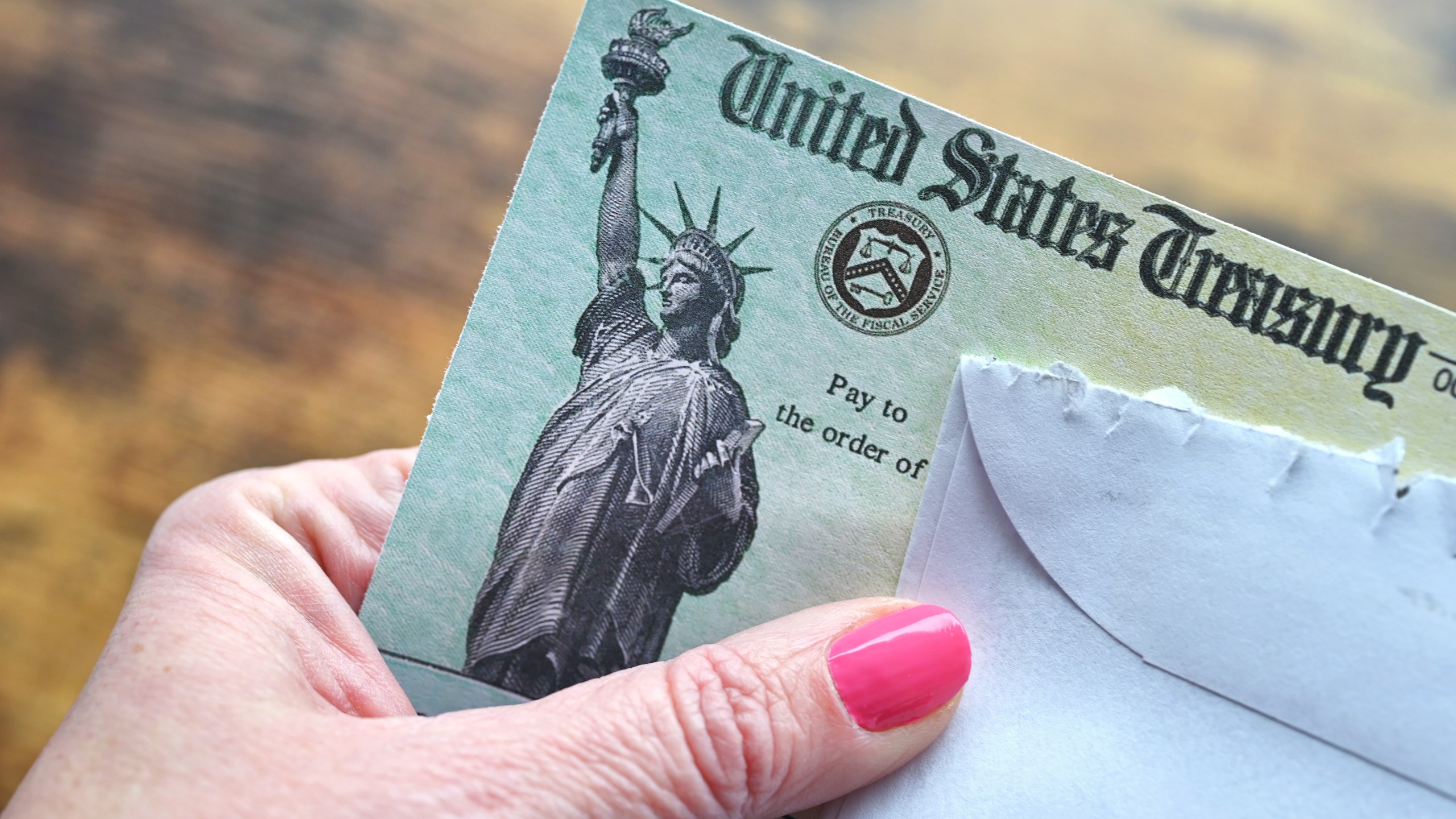 Female holding a check from the United States Treasury