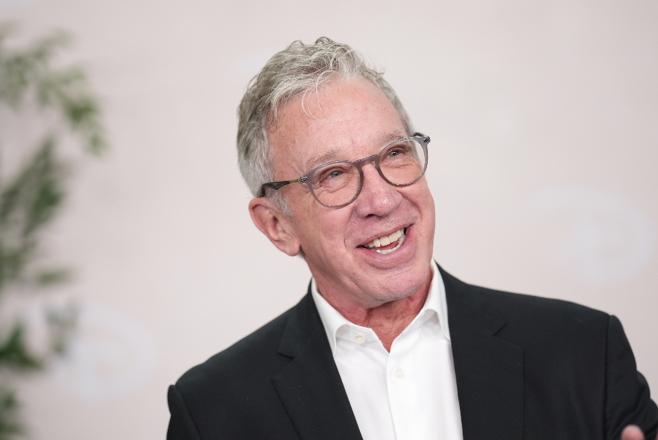Tim Allen smiles for photos at an event