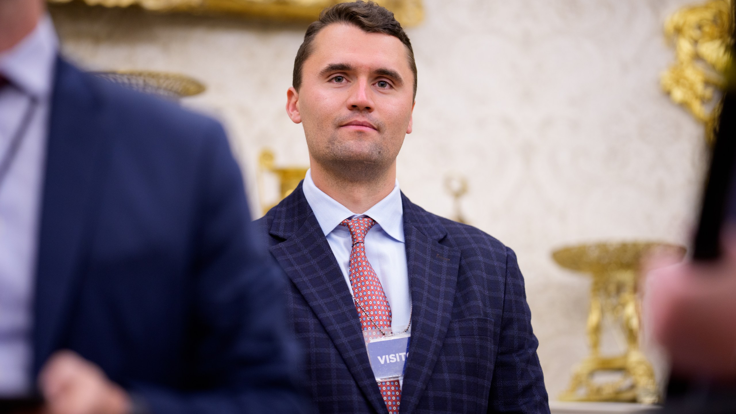 WASHINGTON, DC - MAY 28: Turning Point USA co-founder Charlie Kirk stands in the back of the room as U.S. President Donald Trump speaks during a swearing in ceremony for interim U.S. Attorney for Washington, D.C. Jeanine Pirro in the Oval Office of the White House on May 28, 2025 in Washington, DC. Trump has announced Pirro, a former Fox News personality, judge, prosecutor, and politician, after losing support in the Senate for his first choice, Ed Martin, over his views on the January 6, 2021 attack on the U.S. Capitol. (Photo by Andrew Harnik/Getty Images)