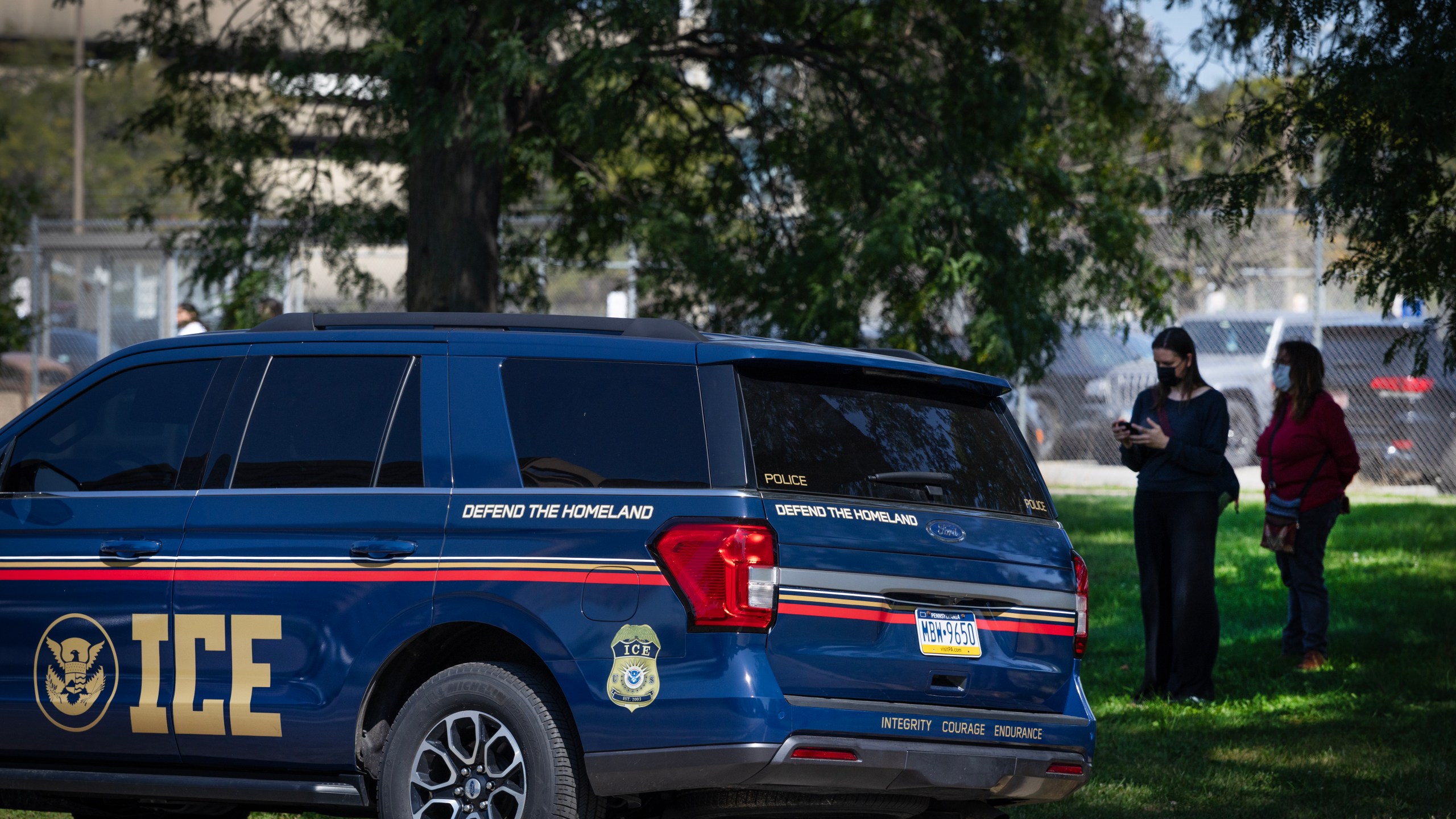Activists monitor a parked ICE vehicle