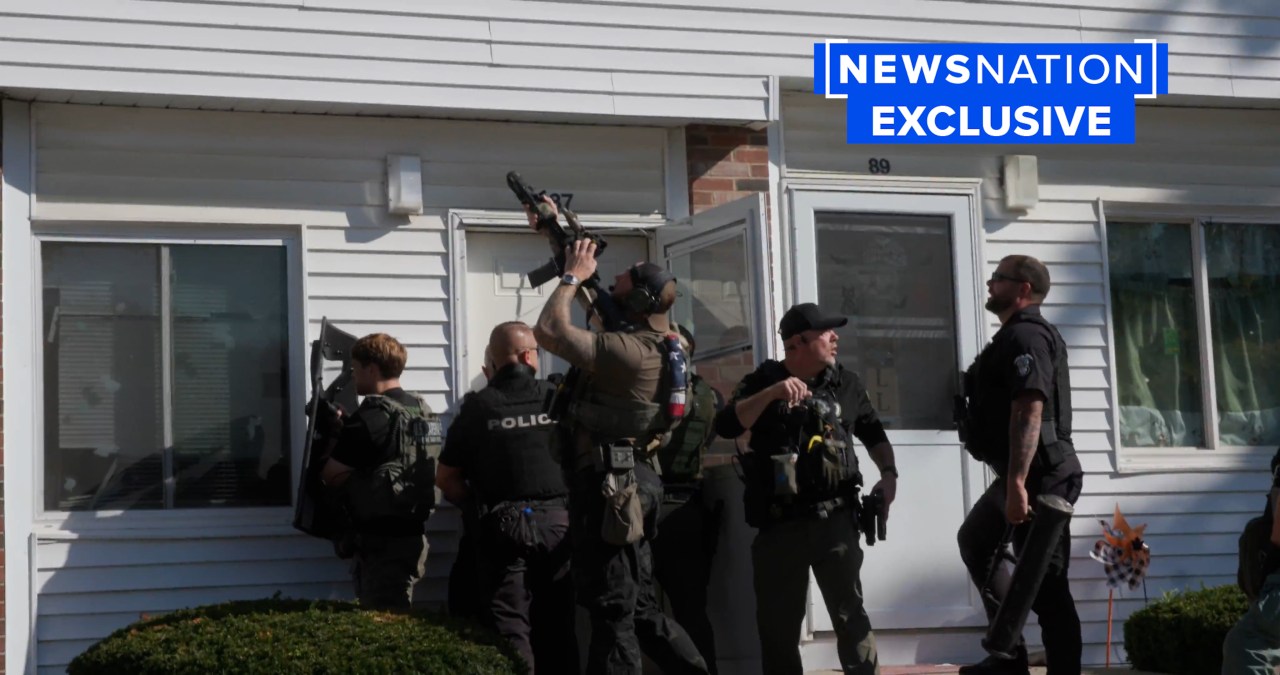 Police surround an apartment door