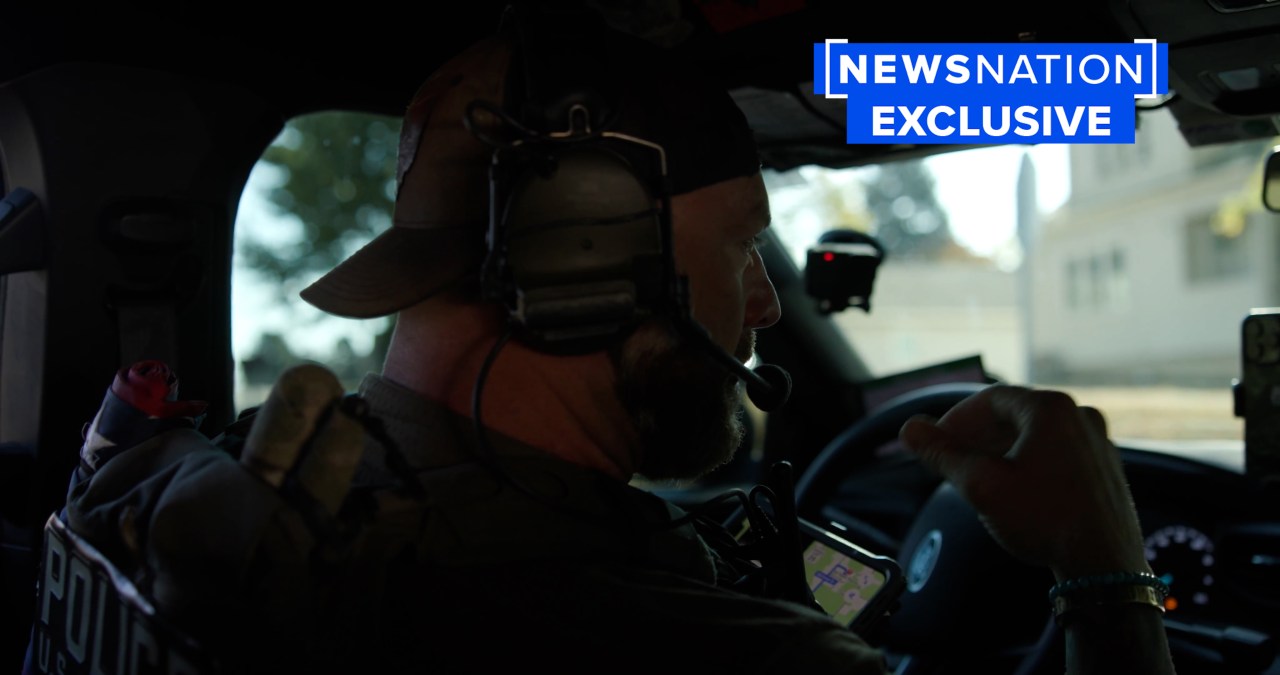 an officer speaks in a patrol car