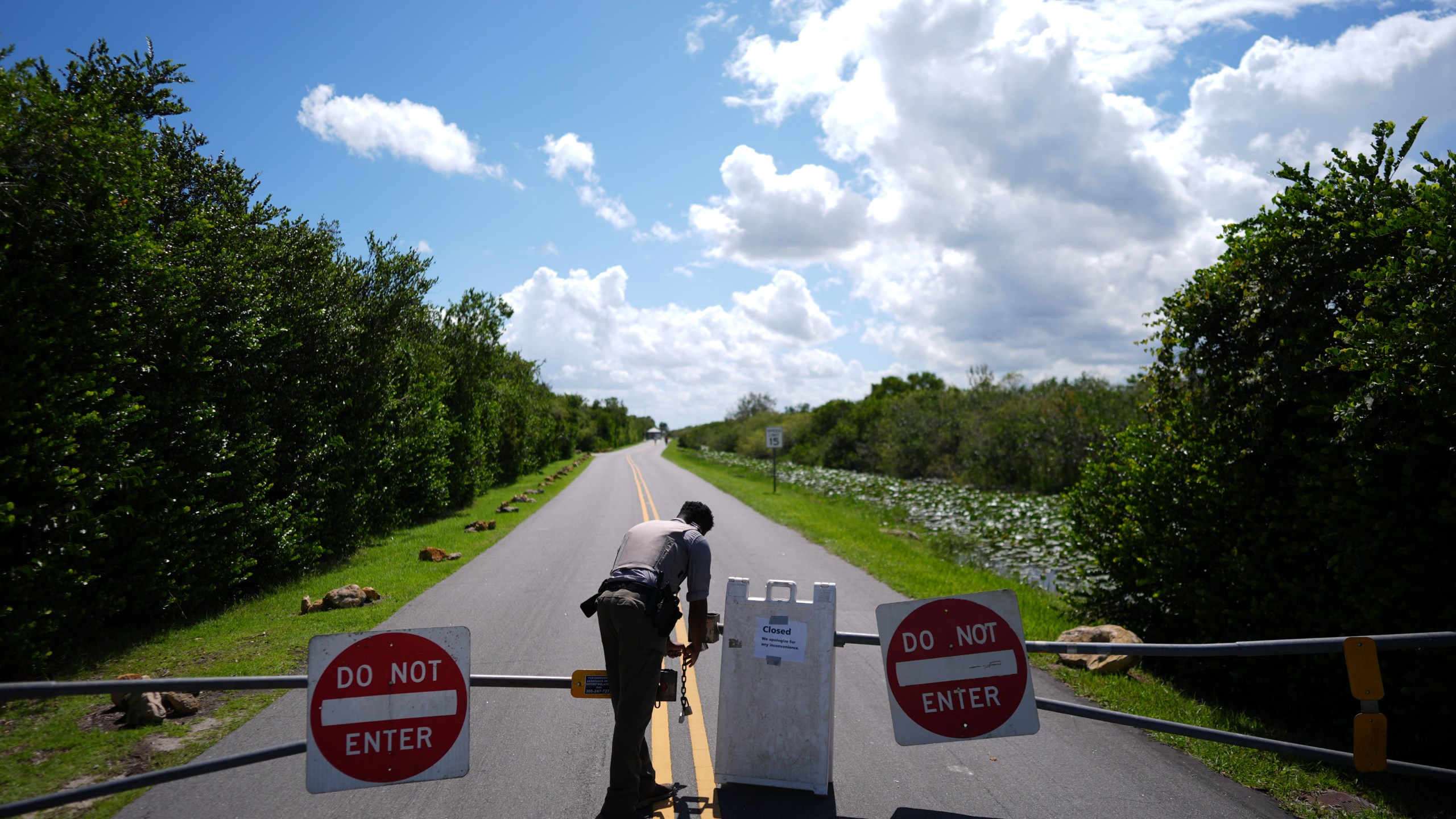 National Park Service law enforcement ranger Greg Freeman opens a locked gate closing vehicle access to the Shark Valley section of Florida's Everglades National Park, as he drives into the park, Wednesday, Oct. 1, 2025. (AP Photo/Rebecca Blackwell)