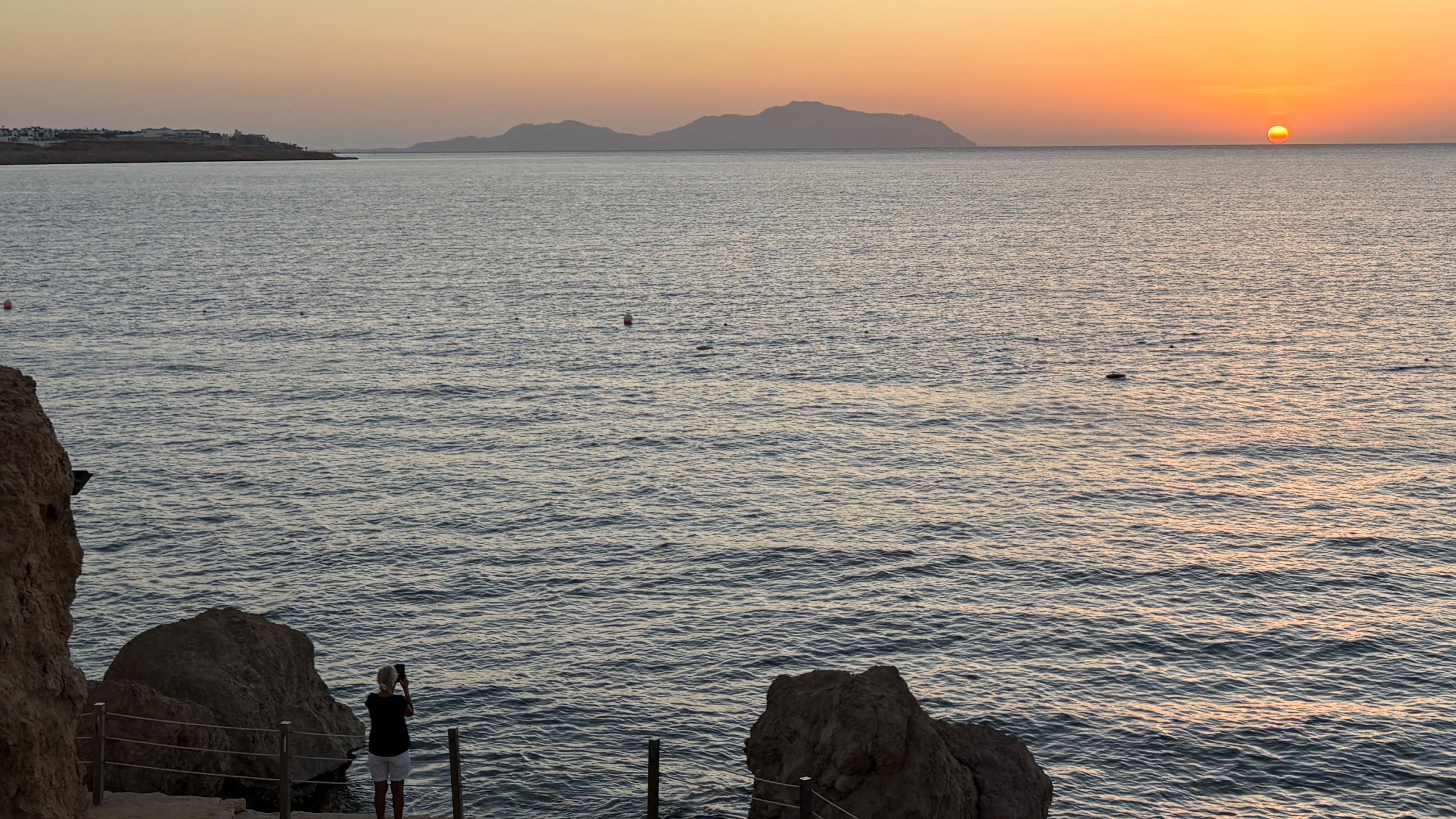 A tourist films the sunrise at the Red Sea city of Sharm el-Sheikh, Egypt, where Israeli and Hamas officials are set to hold indirect talks, on Tuesday, Oct. 7, 2025. (AP Photo)