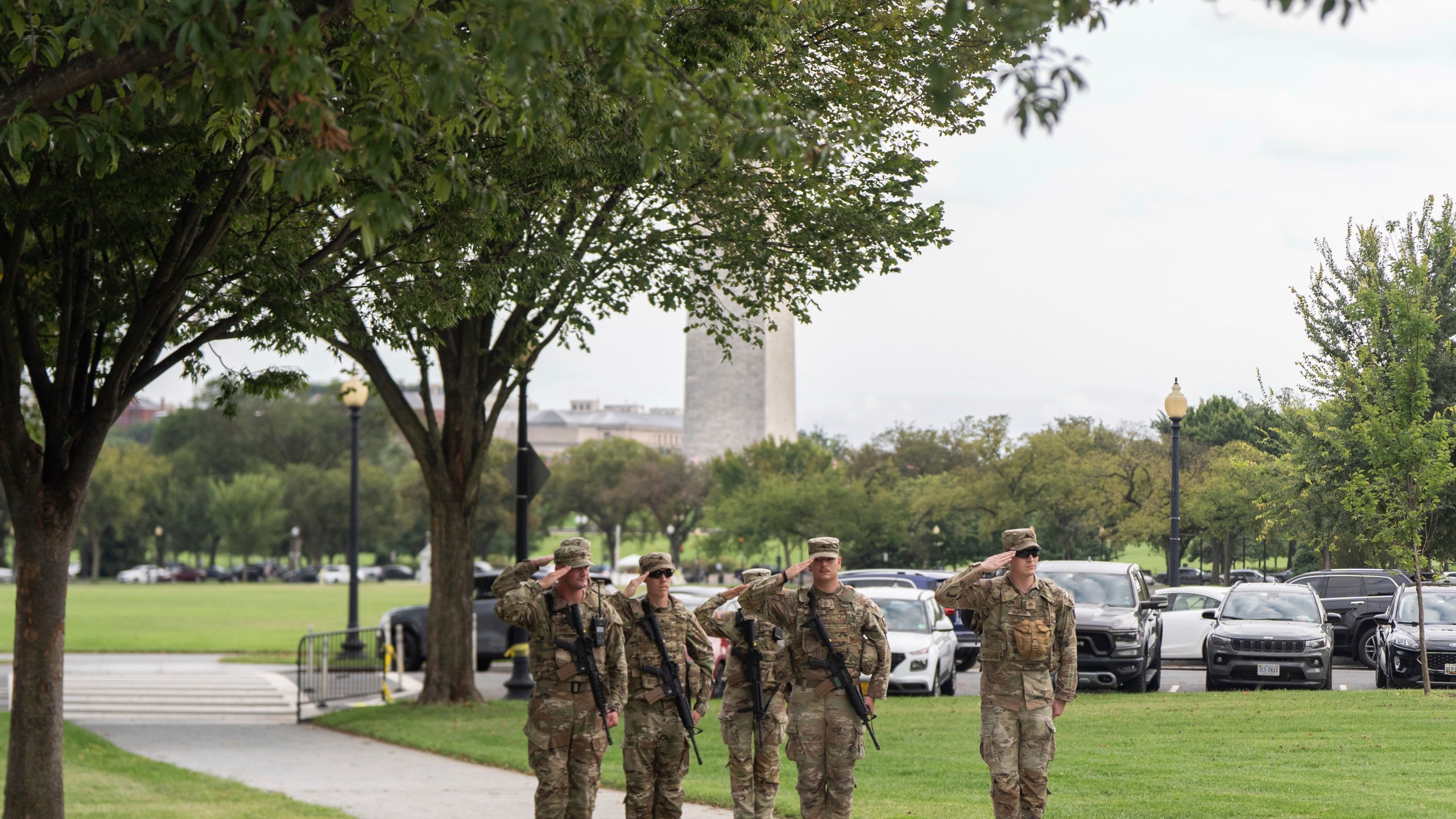 National Guard soldiers salute as President Donald Trump's motorcade drives by, Saturday, Sept. 20, 2025, in Washington. (AP Photo/Julia Demaree Nikhinson)