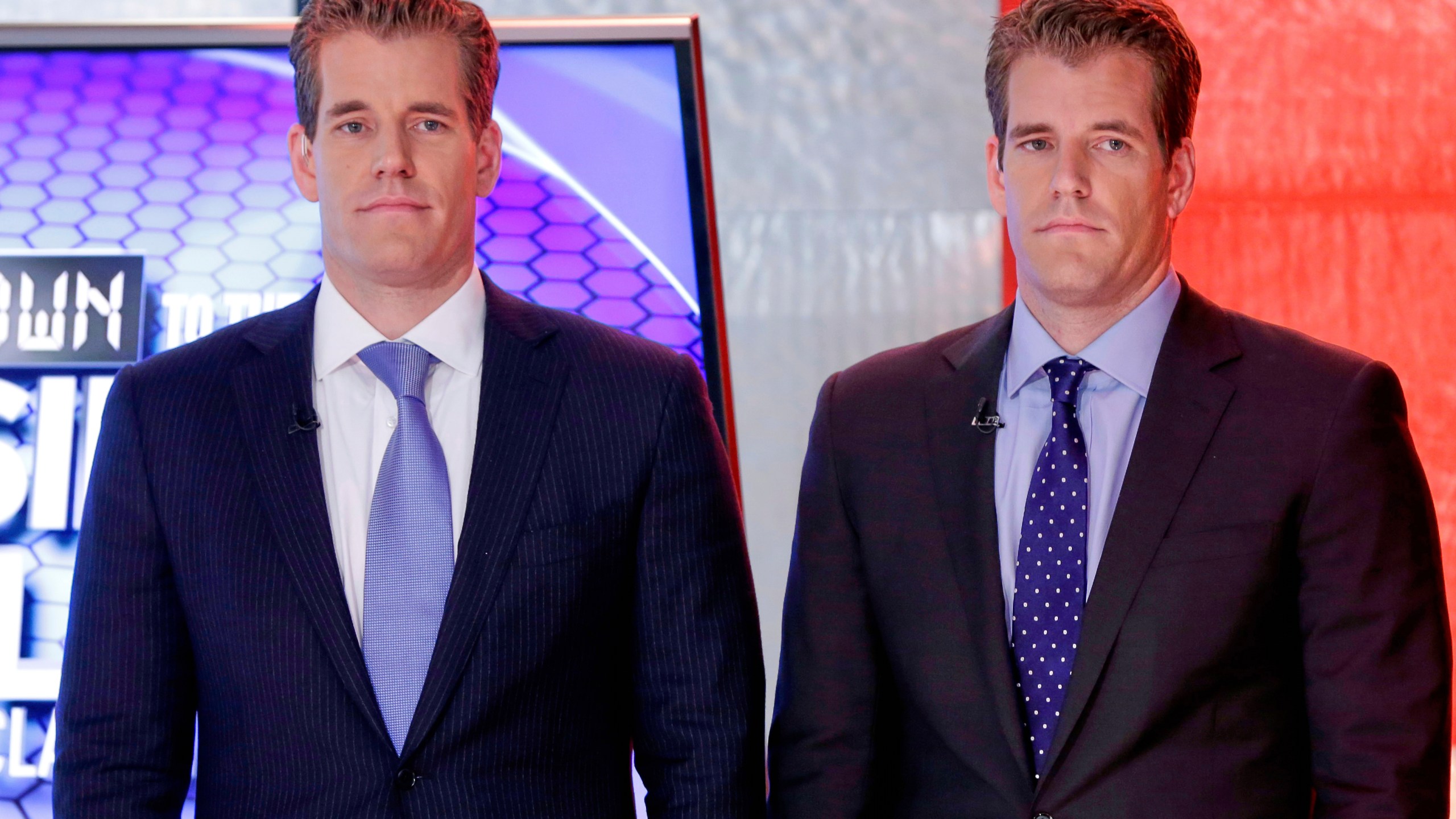 FILE - Cameron Winklevoss, left, and Tyler Winklevoss, founders of Gemini Trust Co., wait to appear on the "Countdown to the Closing Bell with Liz Claman" program, on the Fox Business Network, in New York, Oct. 8, 2015. (AP Photo/Richard Drew, File)