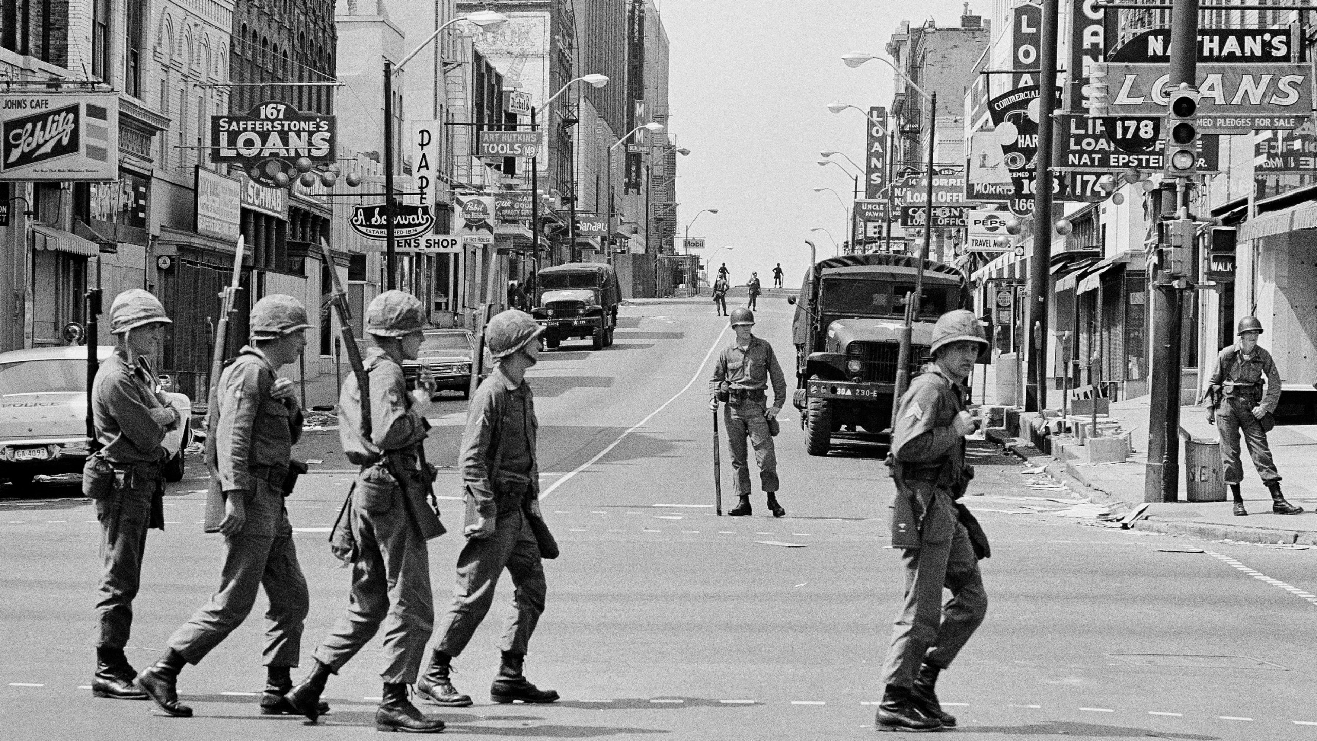 FILE - A relief squad of the Tennessee National Guard files across Beale Street in Memphis, Tenn., to replace troopers already stationed at strategic points in the racially tense city, March 30, 1968. The troops have been on duty in Memphis since violence erupted during a march led by Dr, Martin Luther King Jr. on March 28. (AP Photo/Charles Kelly, File)
