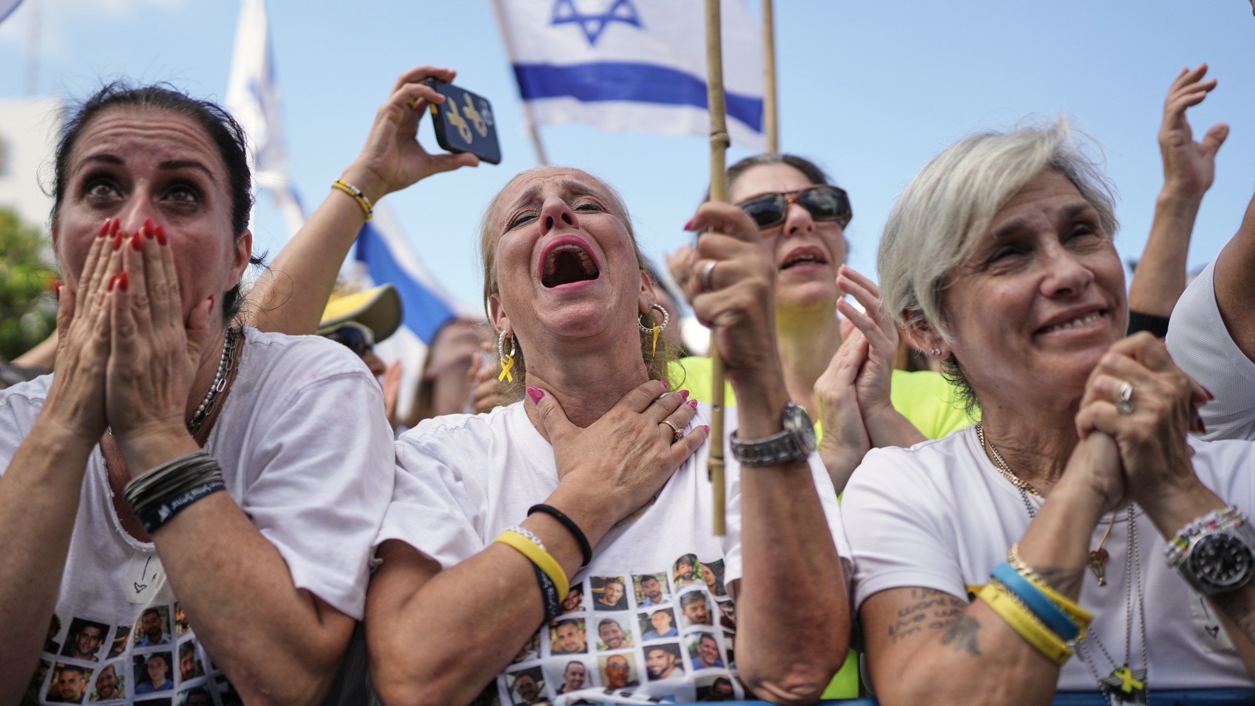 People react as they gather to watch a live broadcast of Israeli hostages released from Gaza at a plaza known as hostages square in Tel Aviv, Israel, Monday, Oct. 13, 2025. (AP Photo/Oded Balilty)
