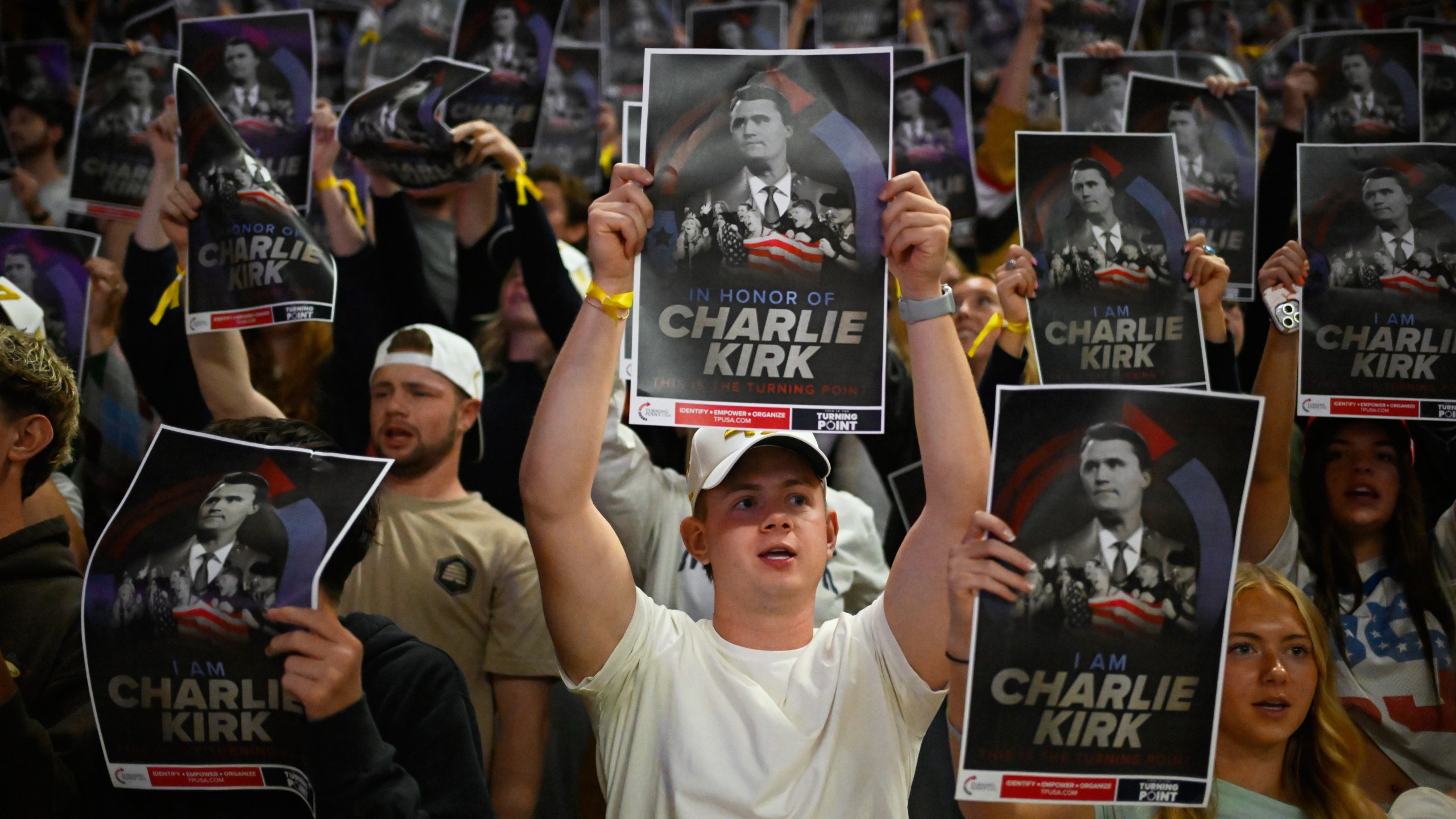 People hold posters of Charlie Kirk during a Turning Point USA rally at Utah State University, as a part of the organization's push to memorialize Kirk, Tuesday, Sept. 30, 2025, in Logan, Utah. (AP Photo/Alex Goodlett)