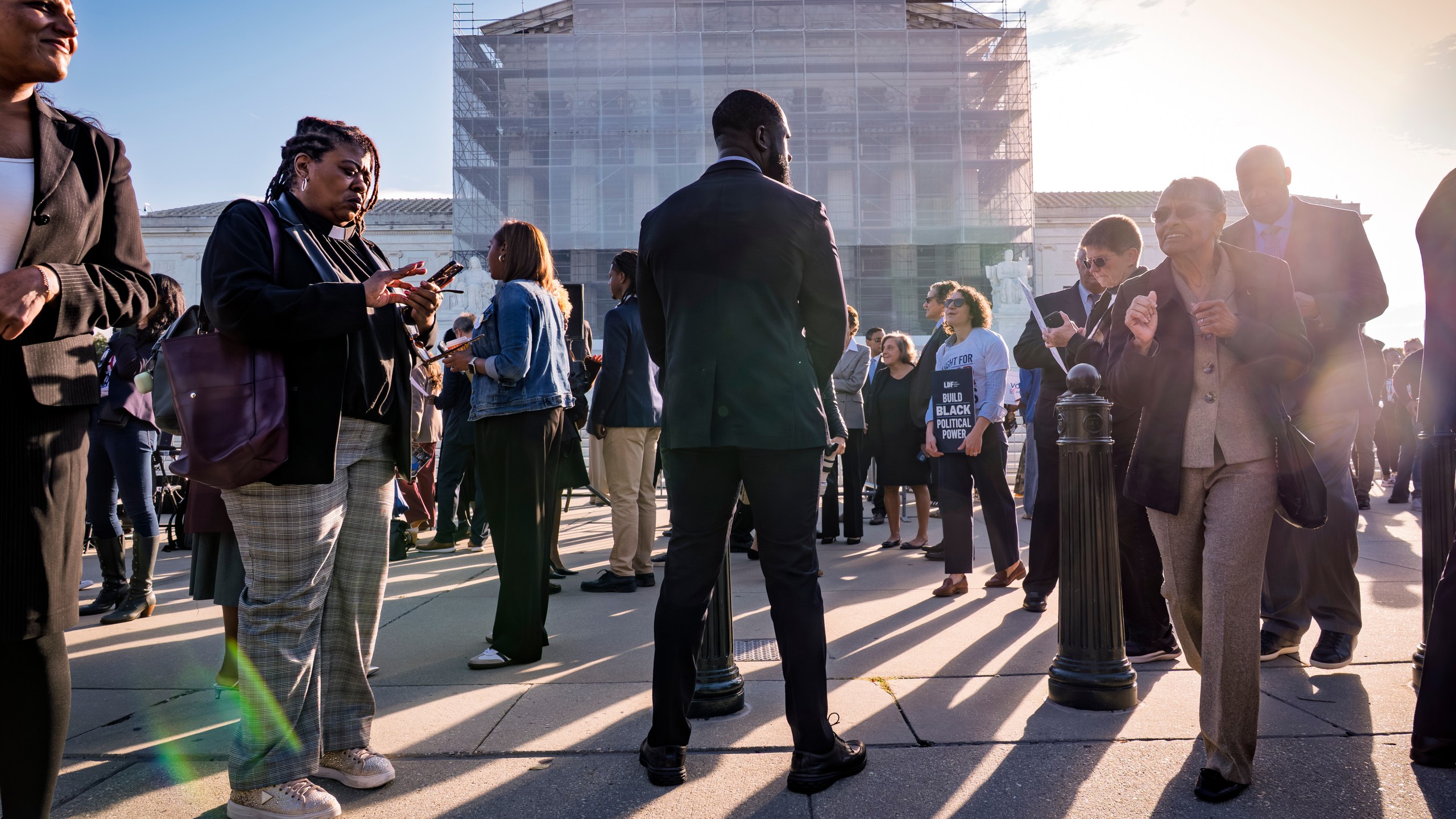Voting rights activists gather outside the Supreme Court in Washington, early Wednesday, Oct. 15, 2025, as the justices prepare to take up a major Republican-led challenge to the Voting Rights Act, the centerpiece legislation of the Civil Rights Movement. (AP Photo/J. Scott Applewhite)
