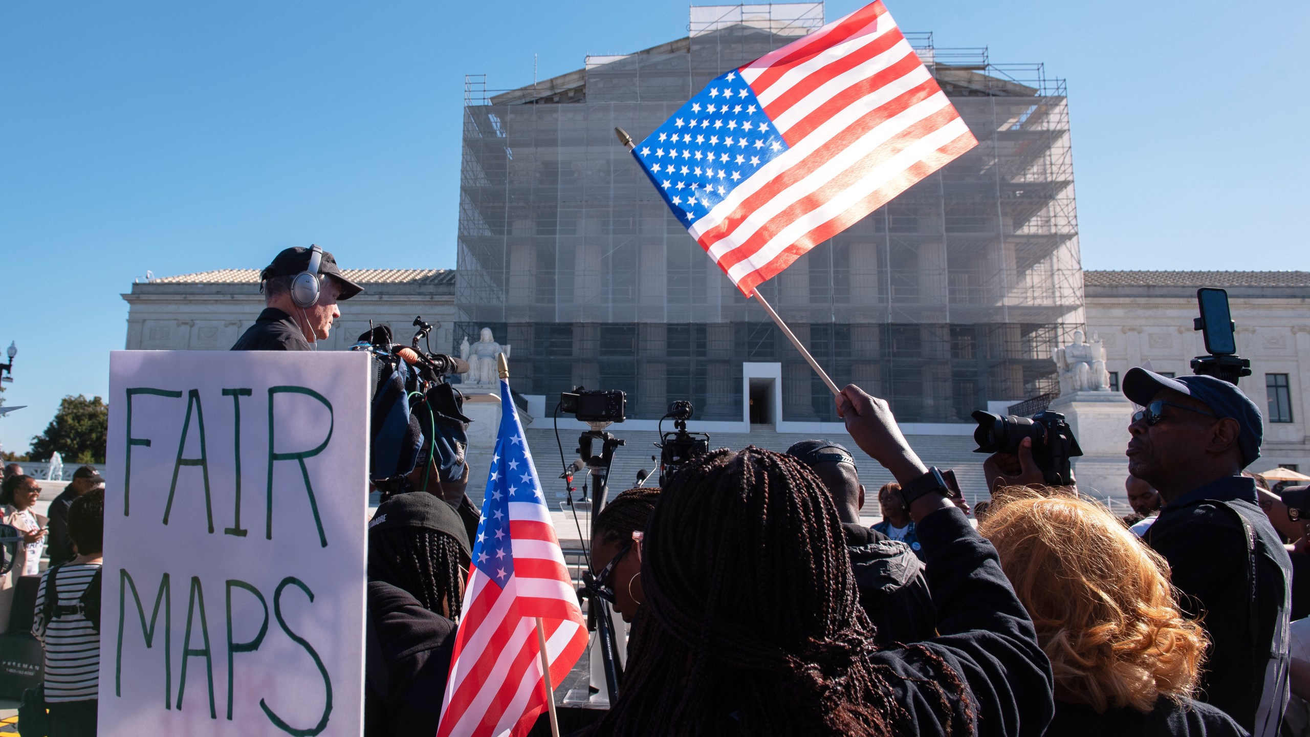 Voting rights activists gather outside the Supreme Court in Washington, early Wednesday, Oct. 15, 2025, as the justices prepare to take up a major Republican-led challenge to the Voting Rights Act, the centerpiece legislation of the Civil Rights Movement. (AP Photo/Cliff Owen)
