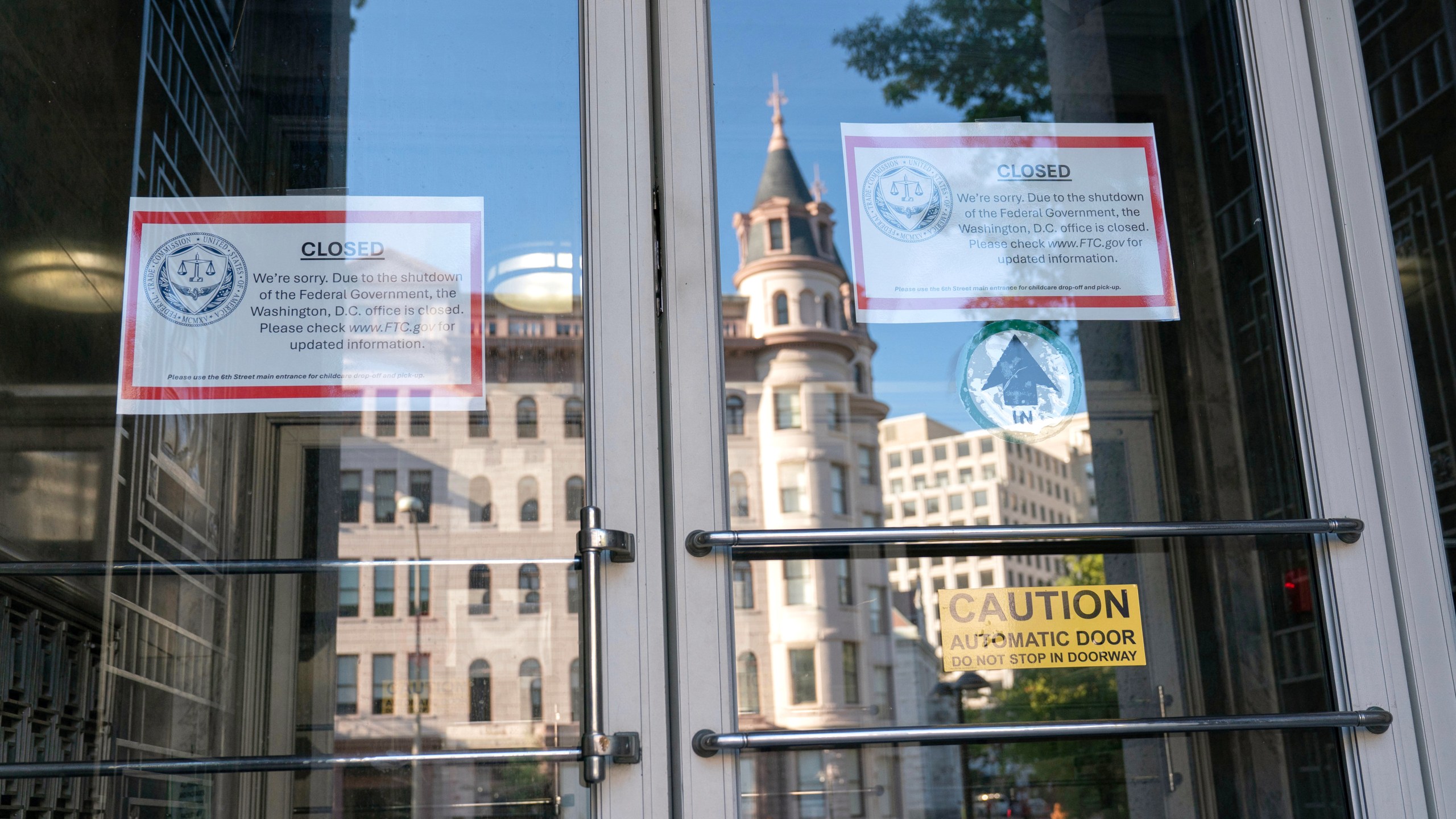Signs that read, "We're sorry. Due to the shutdown of the Federal Government, the Washington, D.C. office is closed." is seen on the doors of the Federal Trade Commission building on the six day of the government shutdown, in Washington, Monday, Oct. 6, 2025. (AP Photo/Jose Luis Magana)