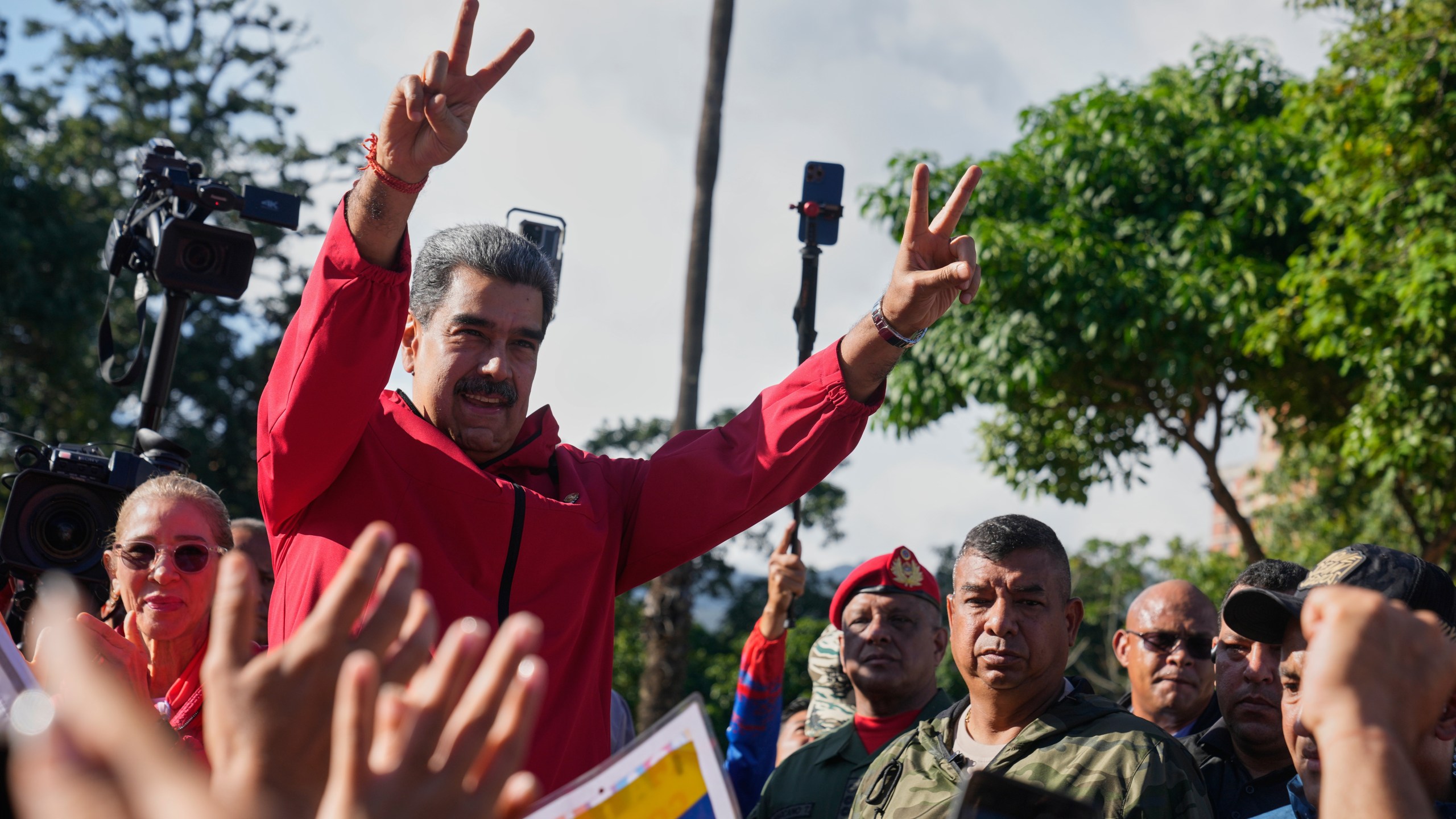 President Nicolas Maduro flashes victory signs during Indigenous Day in Caracas, Venezuela, Sunday, Oct 12, 2025. (AP Photo/Ariana Cubillos)