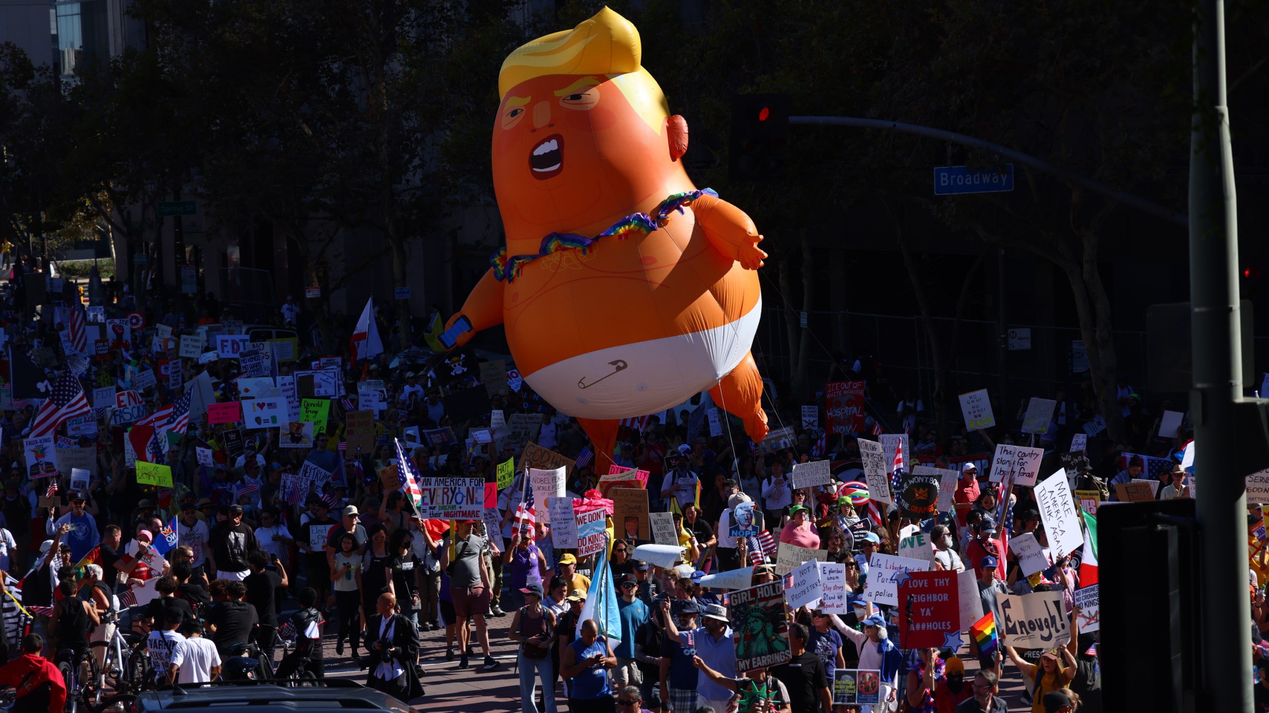 Pulling a giant inflatable Donald Trump protesters march in the streets during a "No Kings" protest Saturday, Oct. 18, 2025, in Los Angeles. (AP Photo/Ethan Swope)