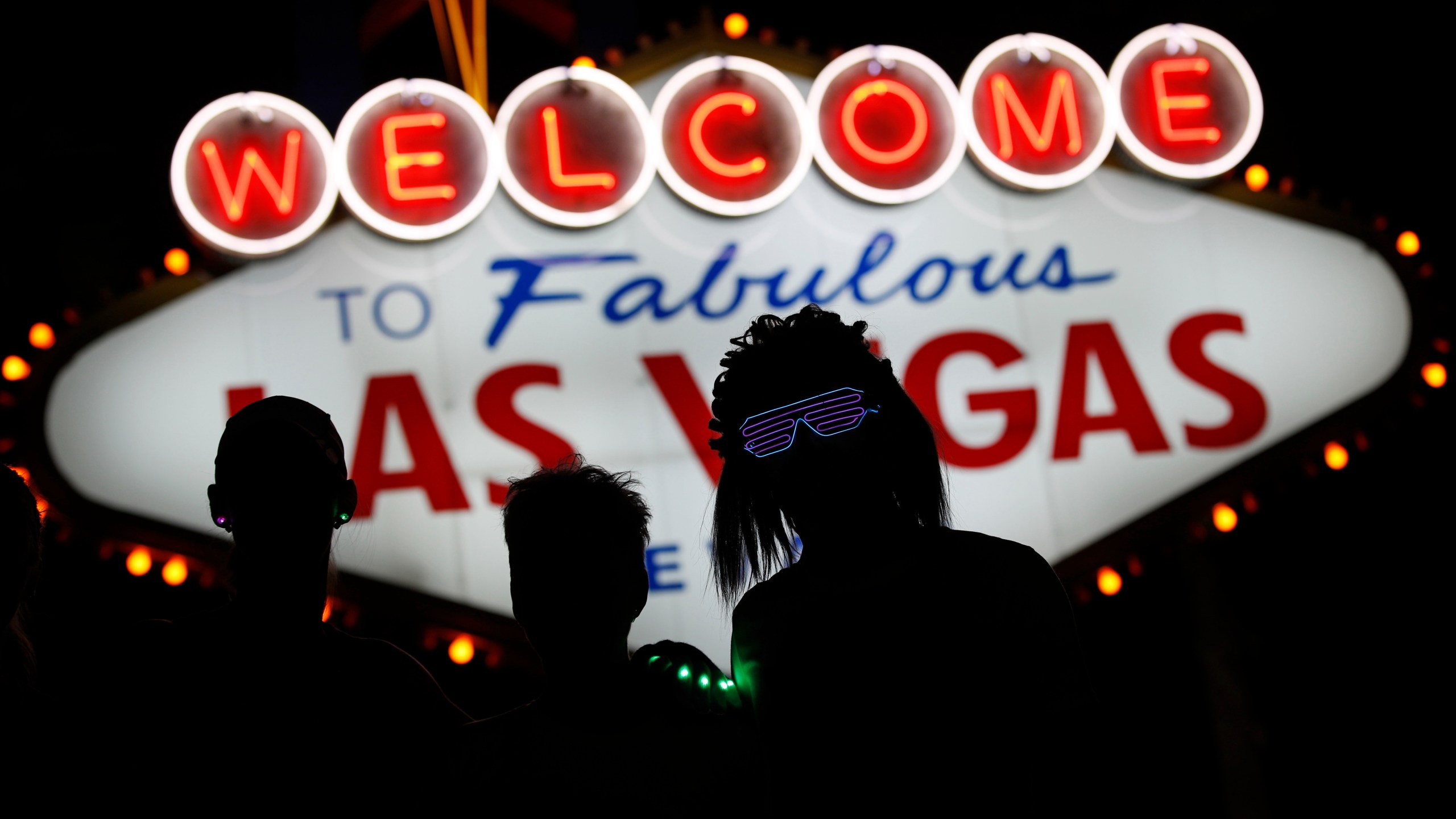 FILE - Runners stop to to have photos taken by official photographers at the Welcome to Las Vegas sign during the Rock 'n' Roll Las Vegas Marathon, Sunday, Nov. 12, 2017, in Las Vegas. (AP Photo/John Locher, File)