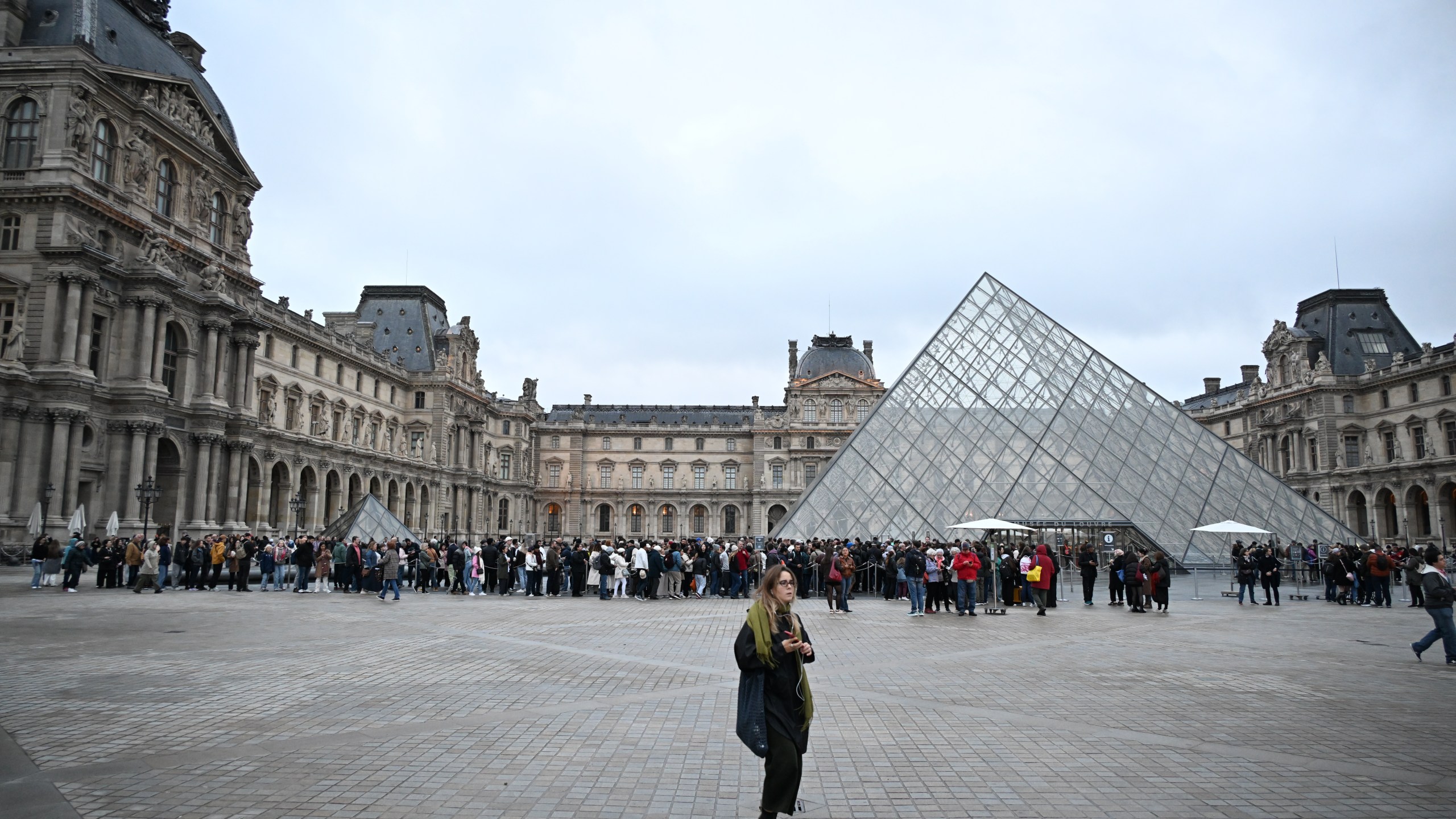 People queue to enter the Louvre museum that will remain closed for the day after Sunday's jewels robbery, Monday, Oct. 20, 2025 in Paris. (AP Photo/Emma Da Silva)
