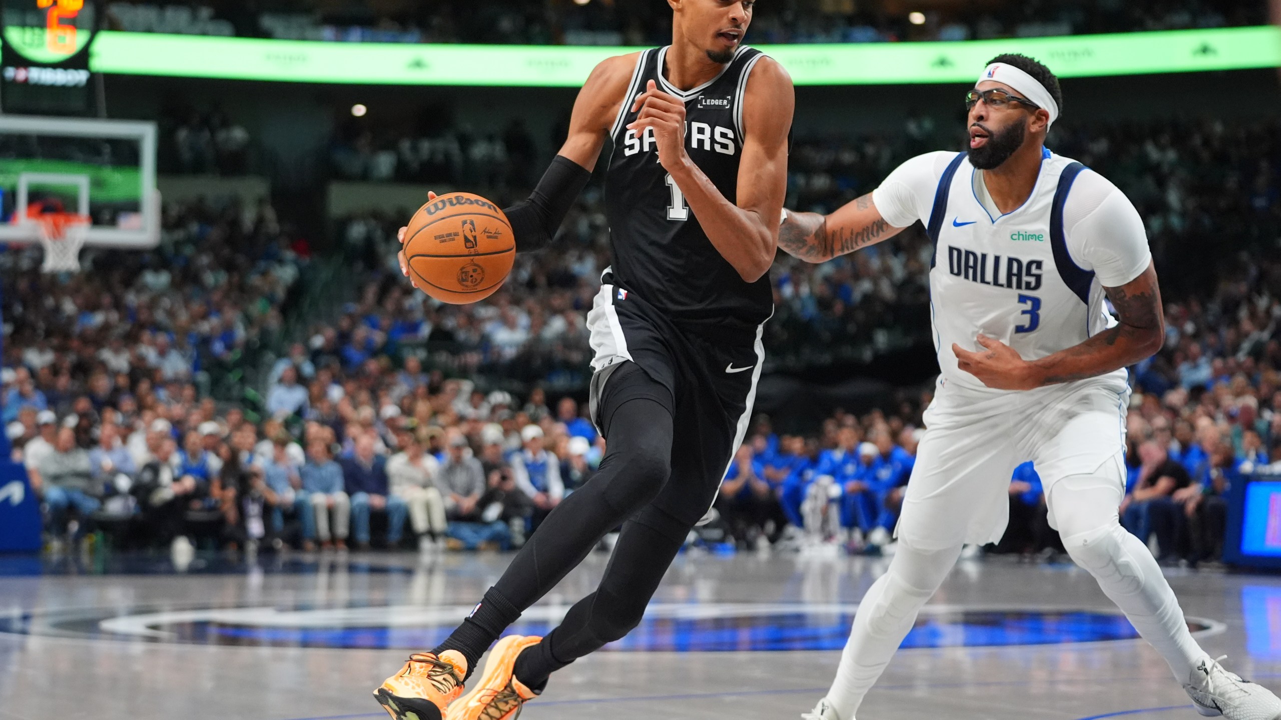 San Antonio Spurs forward Victor Wembanyama (1) drives against Dallas Mavericks forward Anthony Davis (3) during the first half of an NBA basketball game in Dallas, Wednesday, Oct. 22, 2025. (AP Photo/LM Otero)