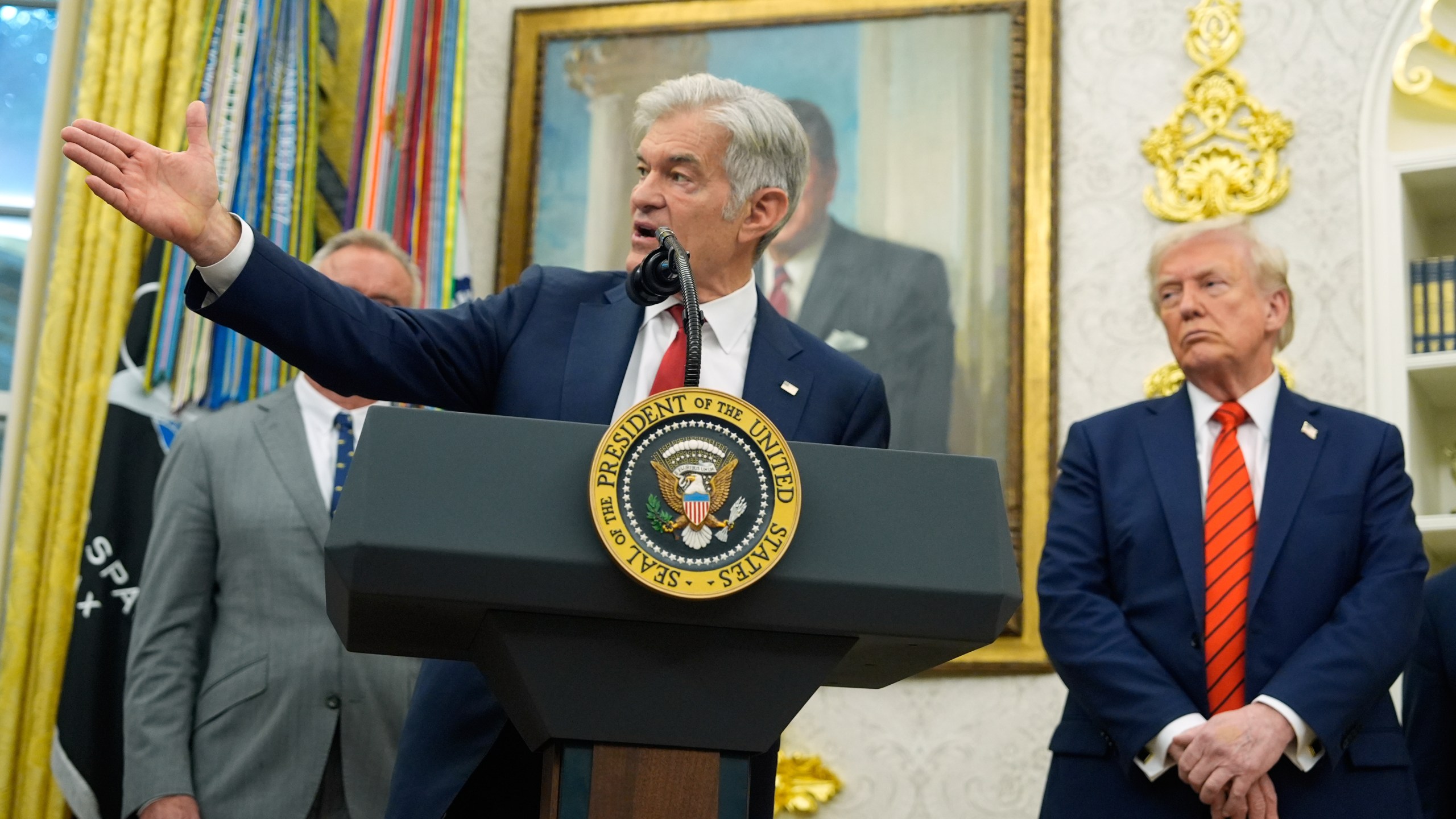 President Donald Trump listens as Centers for Medicare & Medicaid Services administrator Dr. Mehmet Oz speaks in the Oval Office of the White House, Friday, Oct. 10, 2025, in Washington. (AP Photo/Alex Brandon)