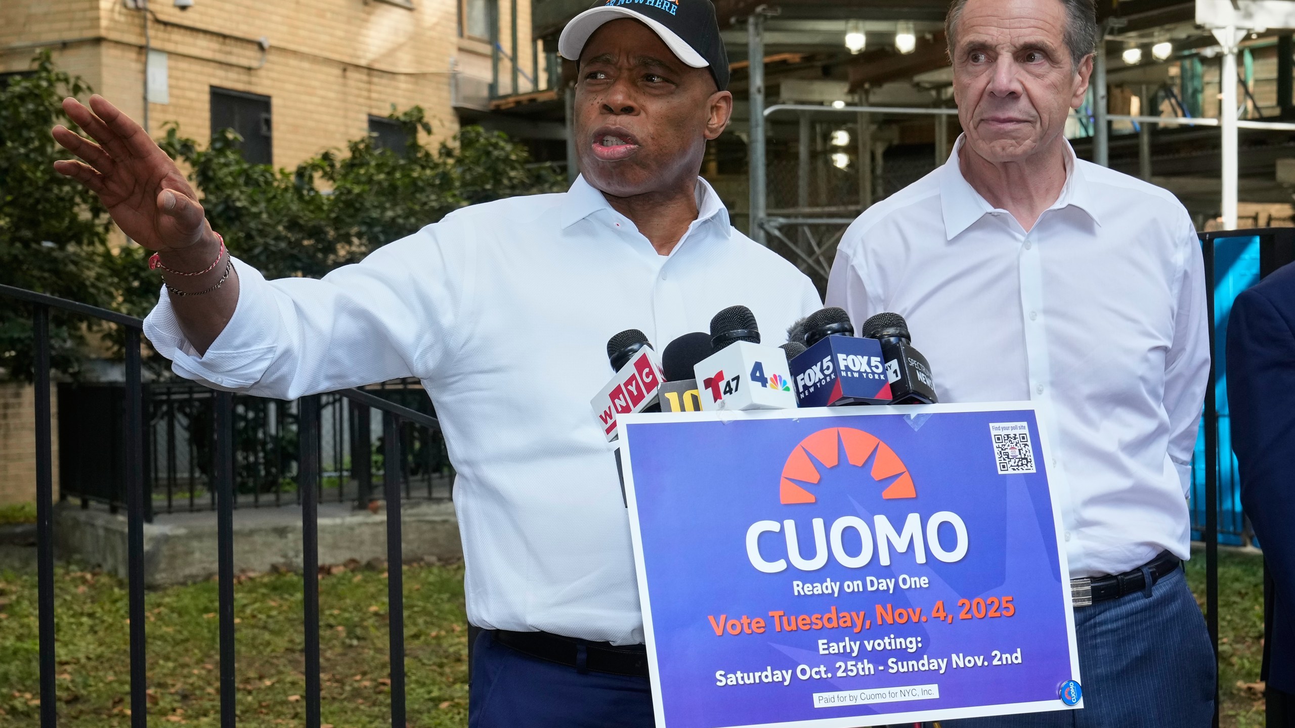 New York Mayor Eric Adams, left, and Democrat mayoral candidate Andrew Cuomo appear at a campaign event outside the George Washington Carver Houses, in New York, Thursday, Oct. 23, 2025. (AP Photo/Richard Drew)