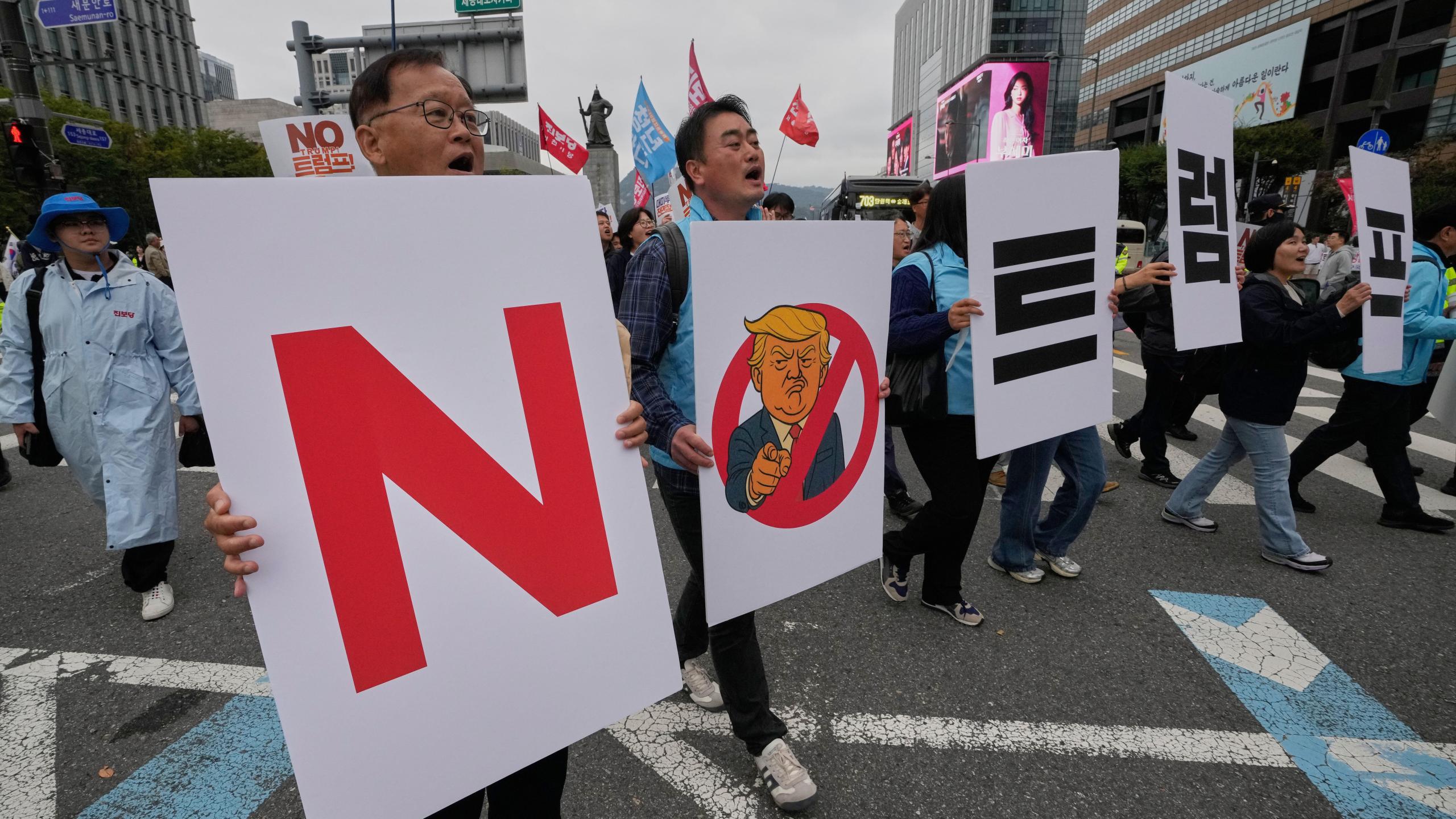 FILE - South Korean protesters march during a rally against U.S. President Donald Trump's tariffs policy on South Korea, in Seoul, South Korea, Oct. 18, 2025. The signs read "No Trump." (AP Photo/Ahn Young-joon, File)