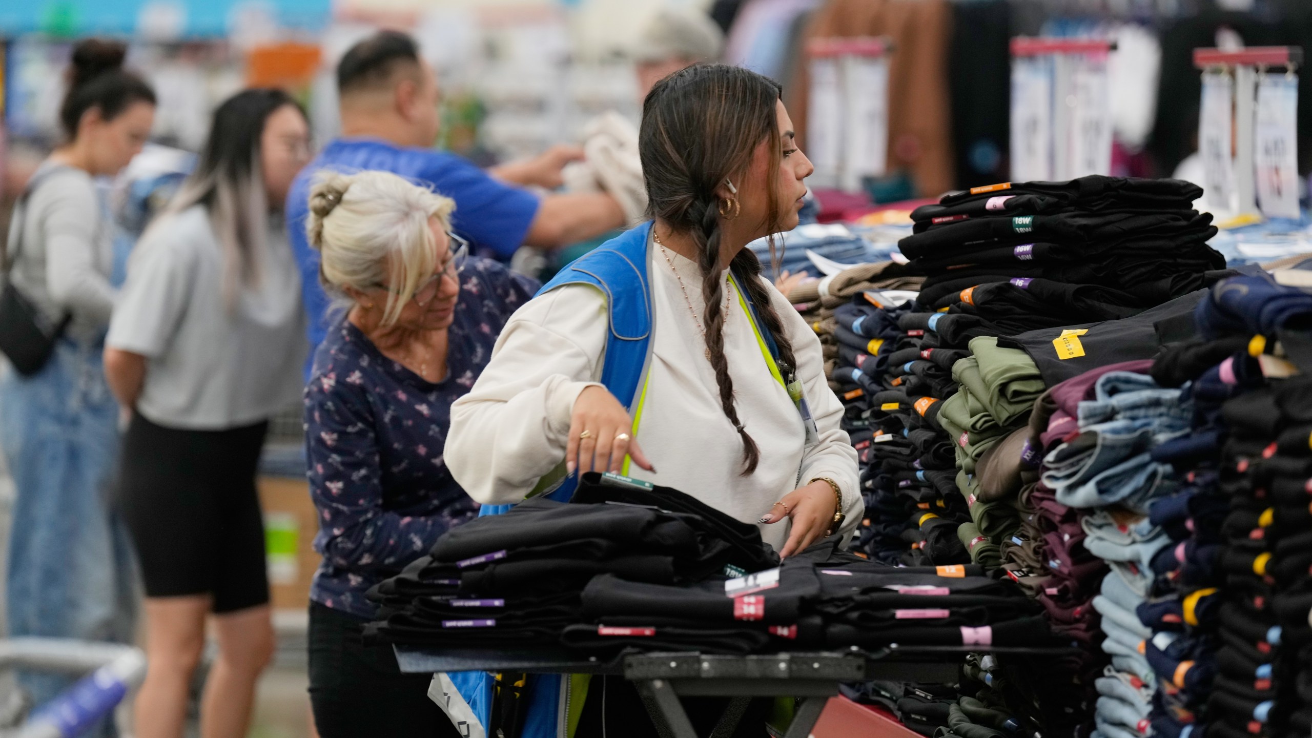 A worker stocks a display of clothing at a Sam's Club, Wednesday, Sept. 24, 2025, in Bentonville, Ark. (AP Photo/Charlie Riedel)