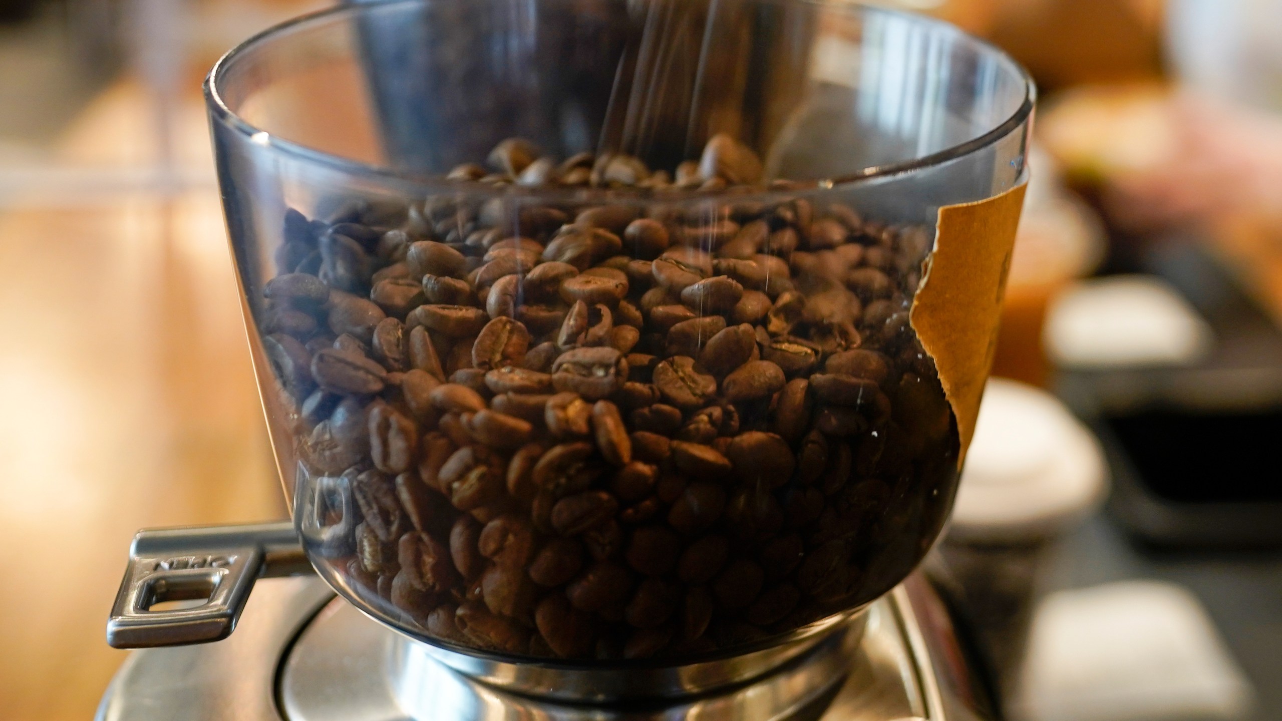FILE - Coffee beans are poured into a grinder at a cafe in College Park, Md., on Wednesday, Sept. 1, 2021. (AP Photo/Julio Cortez, File)