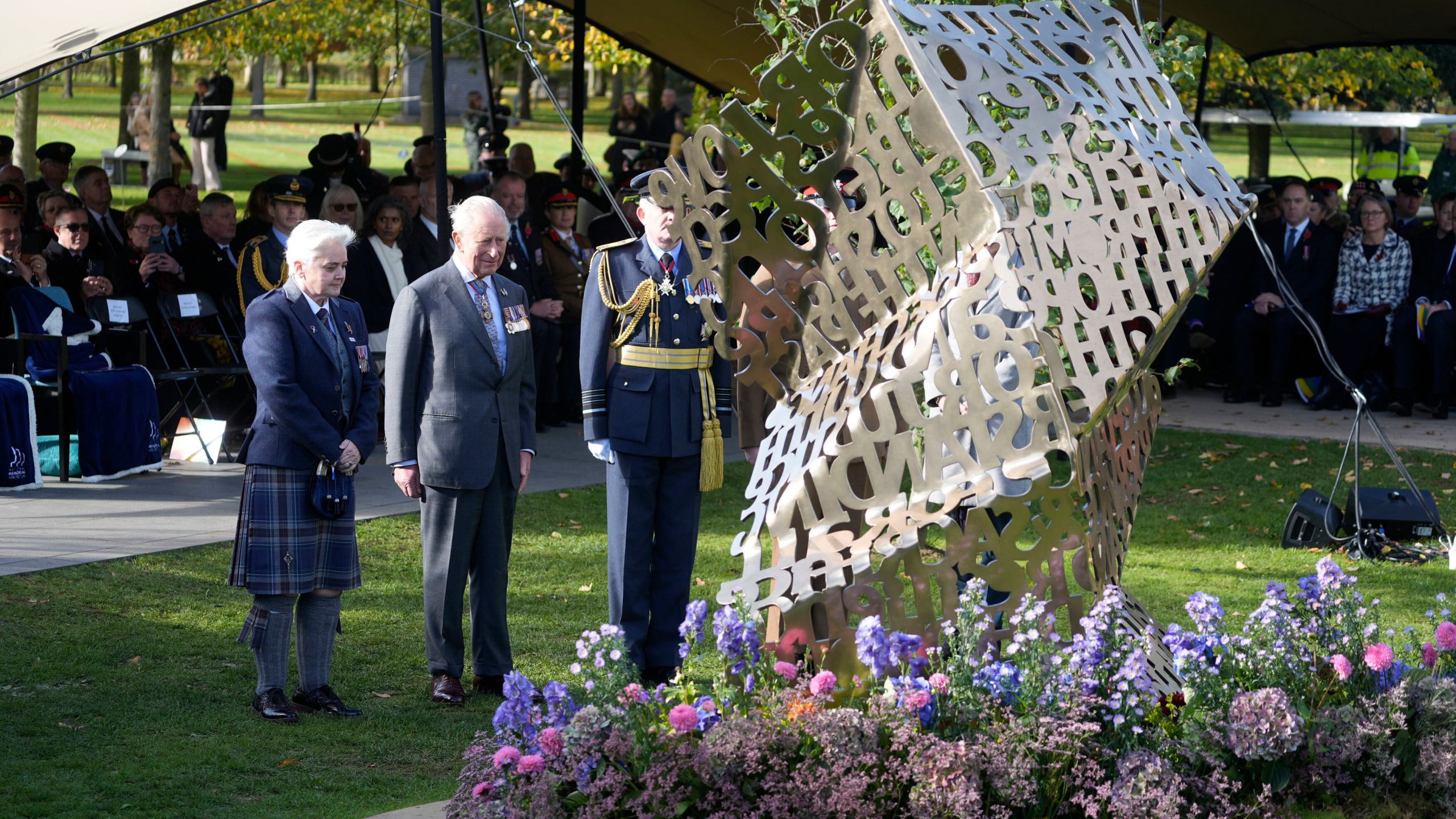 King Charles III stands during a visit to the National Memorial Arboretum in Alrewas, Staffordshire, for the dedication ceremony of the LGBT+ Armed Forces memorial, the UK's first national memorial commemorating LGBT+ people who have served and continue to serve in the military, Monday, Oct. 27, 2025. (Peter Byrne/PA via AP)