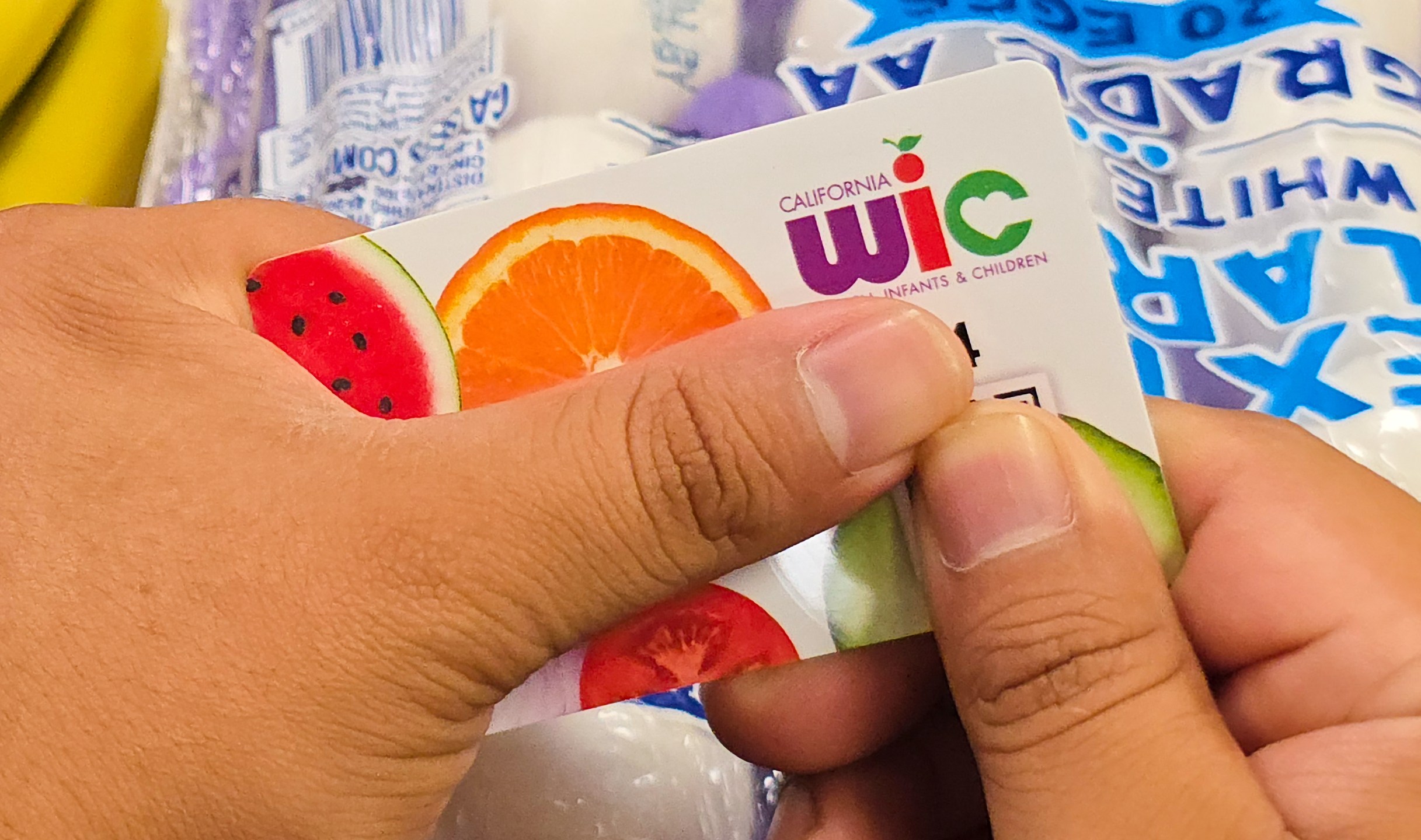 A shopper shows their WIC card on Monday, Oct. 27, 2025, in Los Angeles. (AP Photo/Damian Dovarganes)