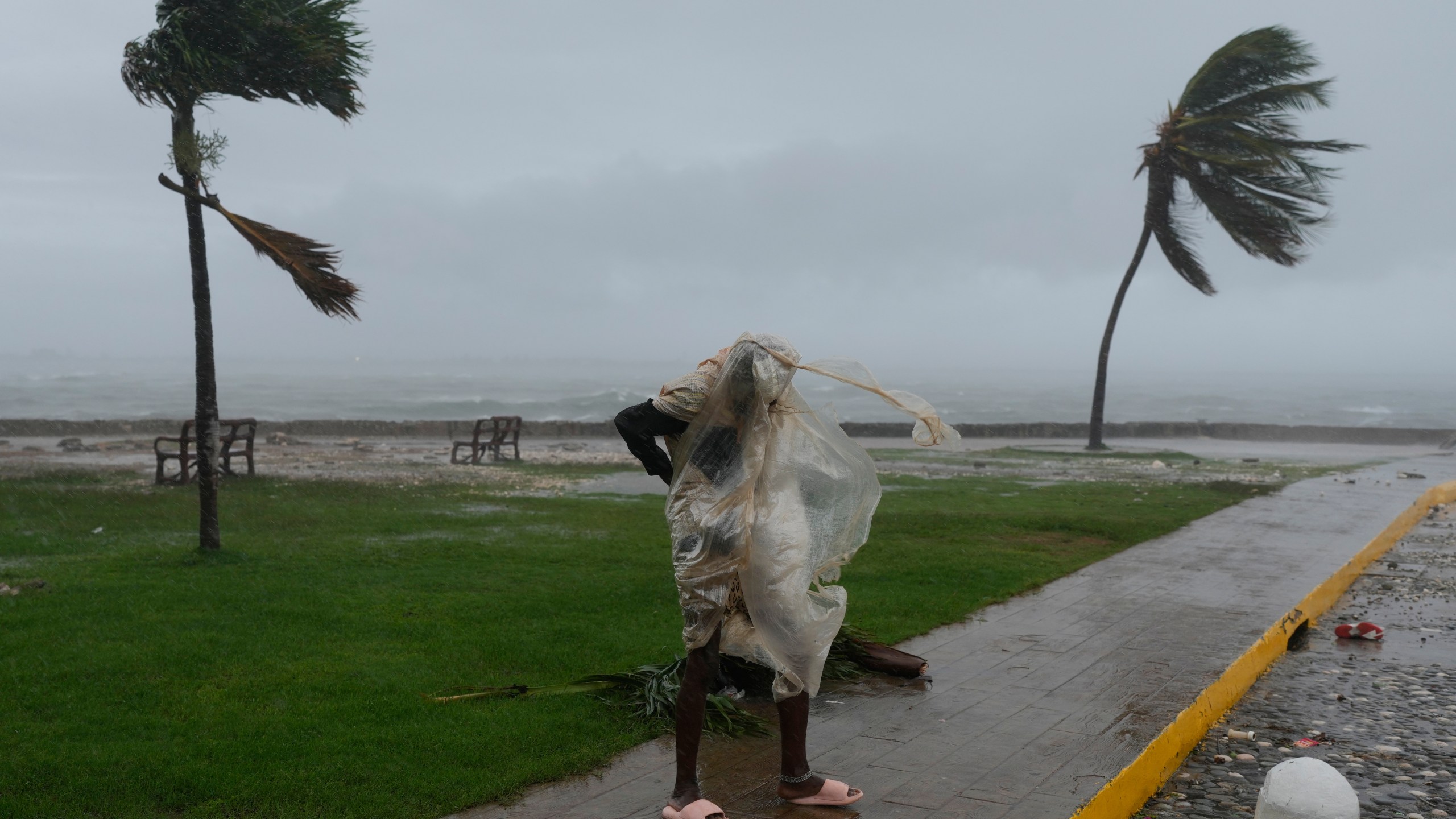 A man walks in Kingston, Jamaica, as Hurricane Melissa approaches, Tuesday, Oct. 28, 2025. (AP Photo/Matias Delacroix)